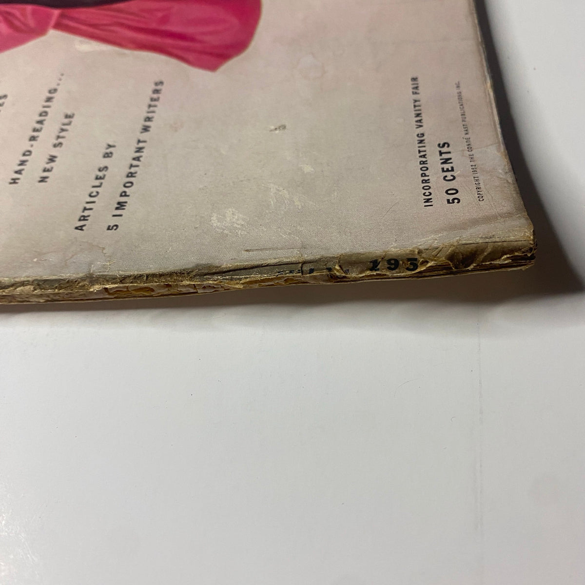 Bottom edge detail of Vogue Magazine July 1952, highlighting the age-related wear with the text '50 cents' visible. Features the Ruth Neumann cover by Irving Penn.