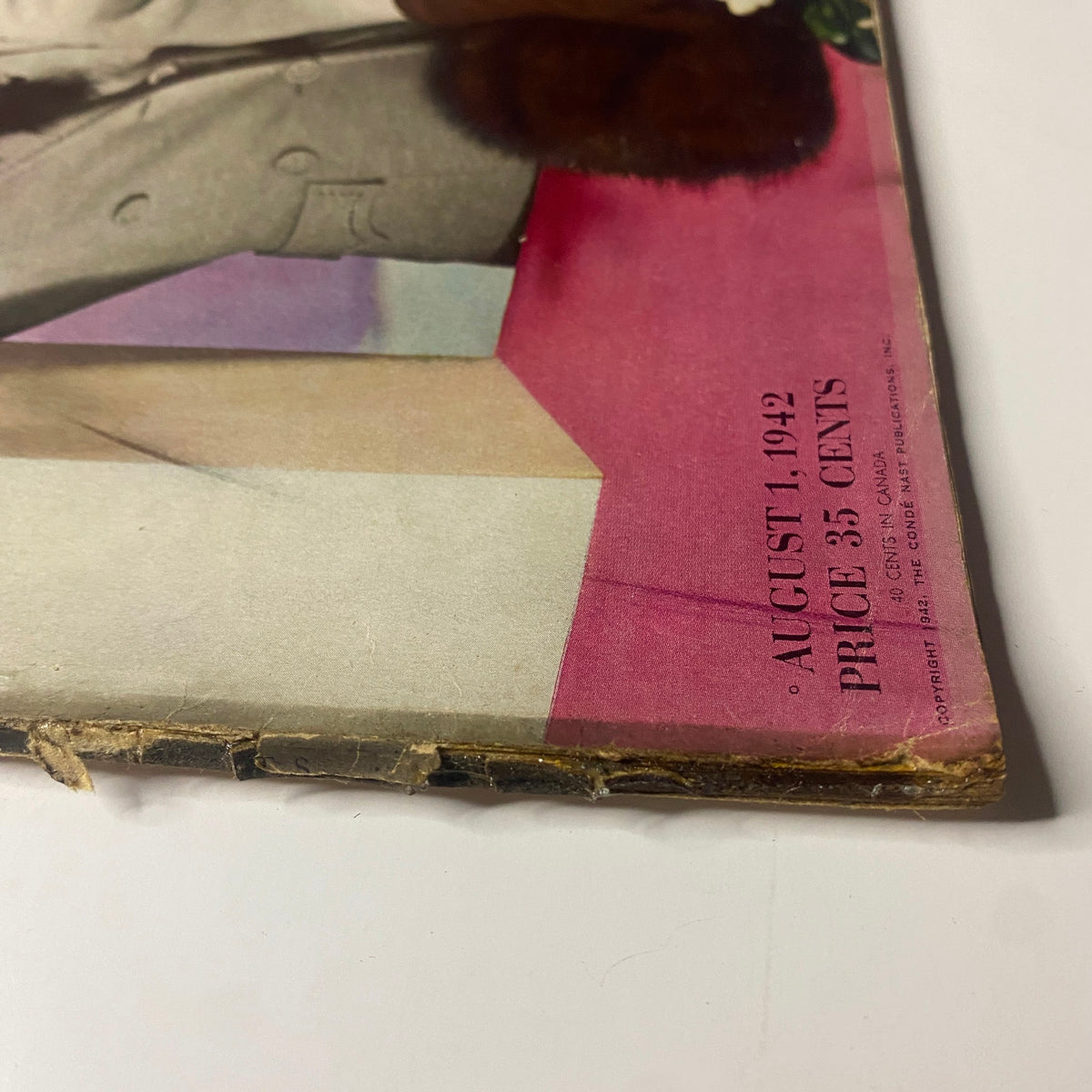 Close-up view of the Vogue Magazine August 1, 1942 cover featuring Lenore Simon illustrated by Horst P. Horst, displaying wear along the spine and highlighting the magazine's vintage essence.