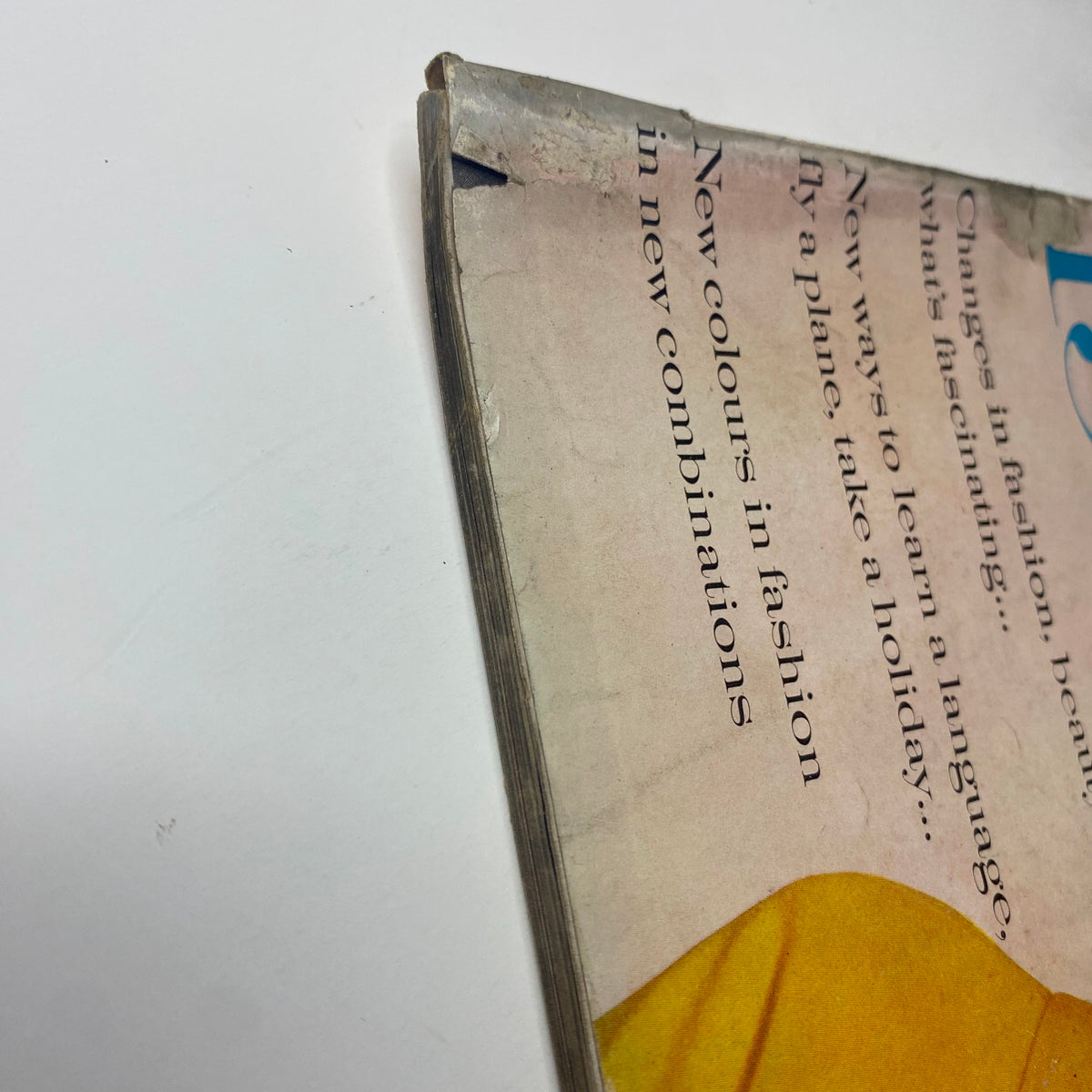 Close-up of the spine and edge of Vogue Magazine January 1, 1961, showing signs of vintage wear, indicative of its history and classic fashion content, featuring Dorothy McGowan Cover by Irving Penn.