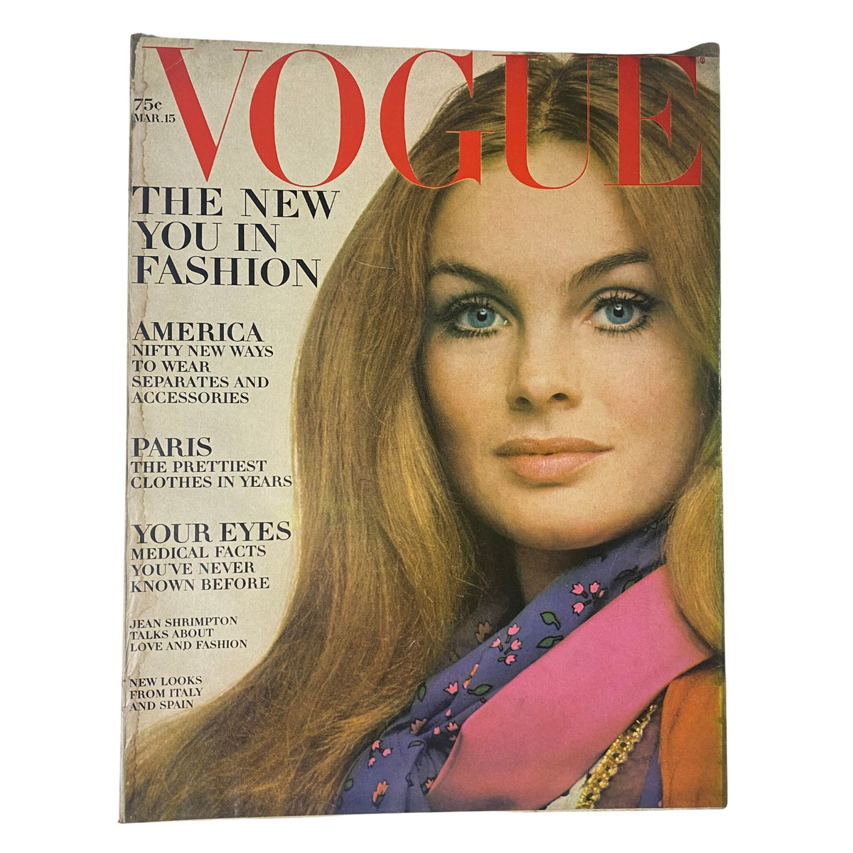 Vogue Magazine March 15, 1969 Jean Shrimpton Cover by Gianni Penati features a model with long red hair and a bold fashion statement. The cover showcases the title and topics like fashion and beauty.