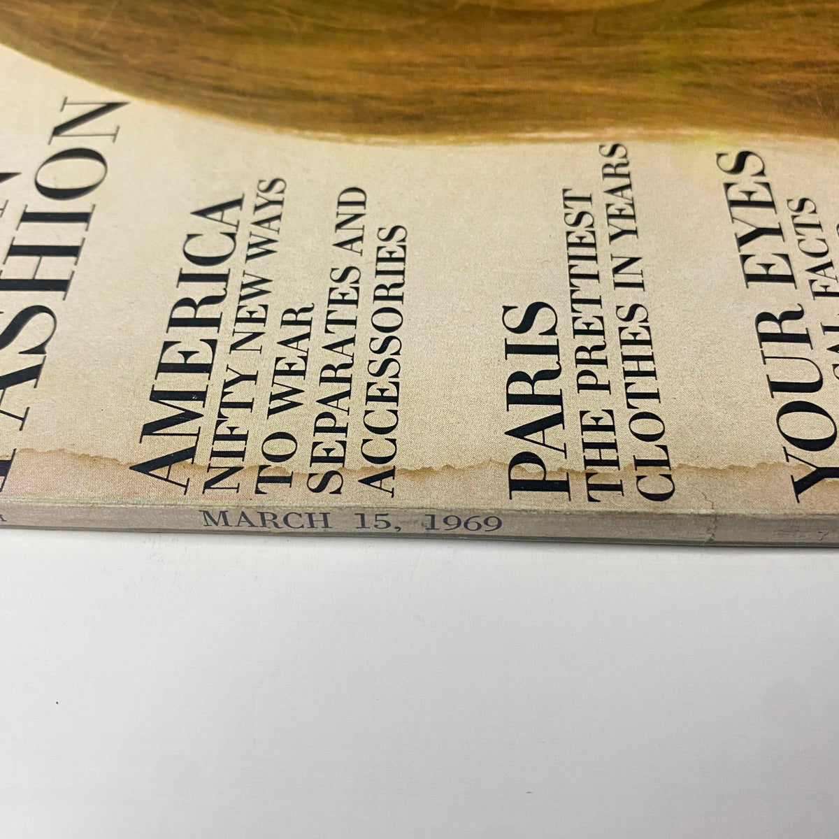 Side view of Vogue Magazine March 15, 1969, highlighting the magazine's edges with vintage wear. The text reveals contents related to fashion in Paris and medical facts about eyes.