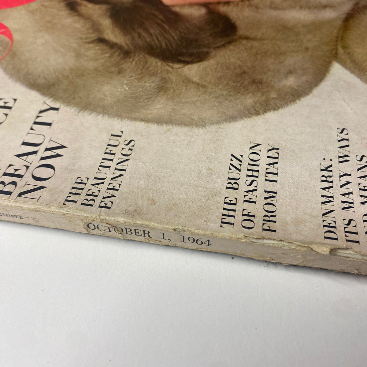 Close-up of the spine of Vogue Magazine, October 1, 1964, featuring 'The Buzz of Fashion from Italy'. Vintage magazine details reveal wear indicative of its storied history.