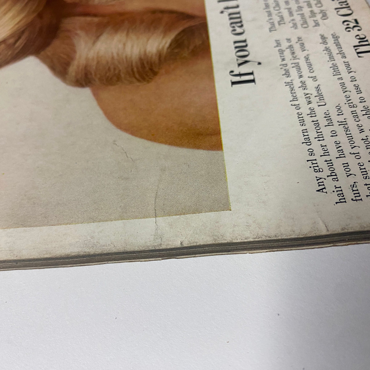 Close-up of the edge wear on Vogue Magazine February 15, 1969, highlighting the magazine's vintage condition, with a noticeable crease near the cover.