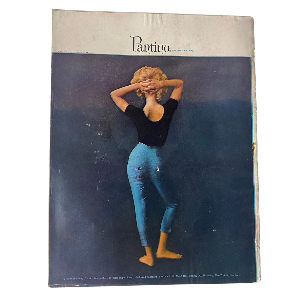 Cover of Vogue Magazine April 15, 1961 featuring a model in a black top and blue pants against a gradient background, illustrating iconic mid-century fashion.