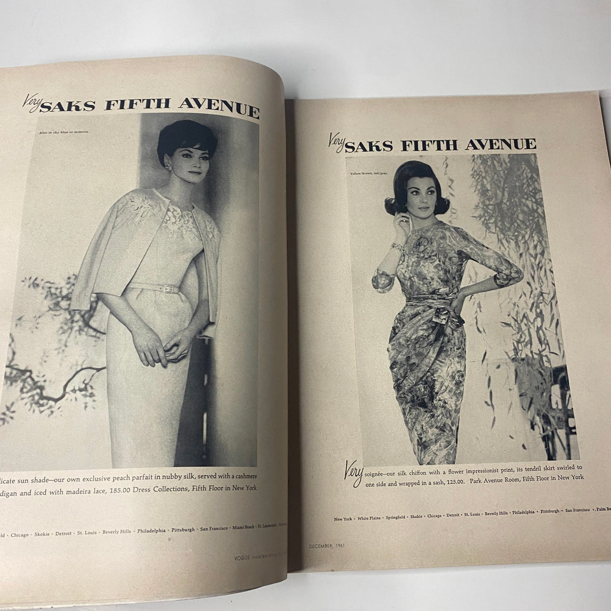 Saks Fifth Avenue advertisement showcasing elegant fashion designs in Vogue Magazine December 1961 featuring models in stylish outfits. Original Vogue Magazine December 1961 Antonia Boekestyn Cover by Horst P. Horst.