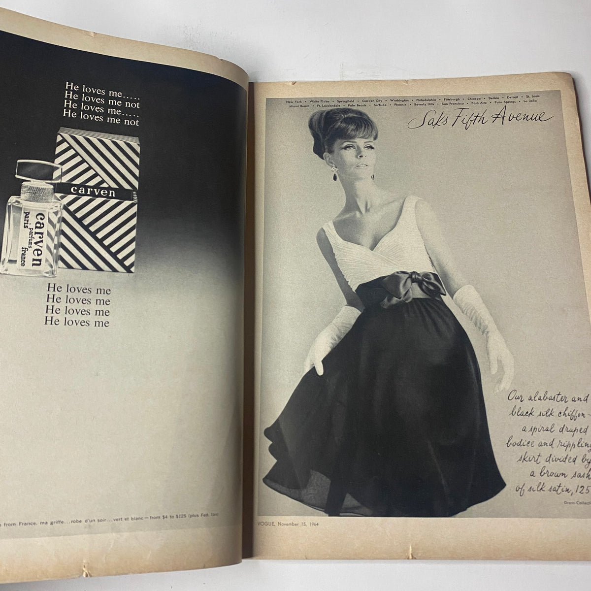 Spread from Vogue Magazine November 15, 1964, featuring fashion photography showcasing a model in a classic black dress with the tagline "He loves me...".