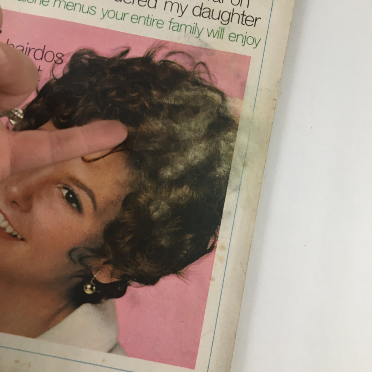 Close-up of Good Housekeeping Magazine April 1970 cover, highlighting a smiling woman with curly hair and the article title about 24 new hairdos and makeup ideas.