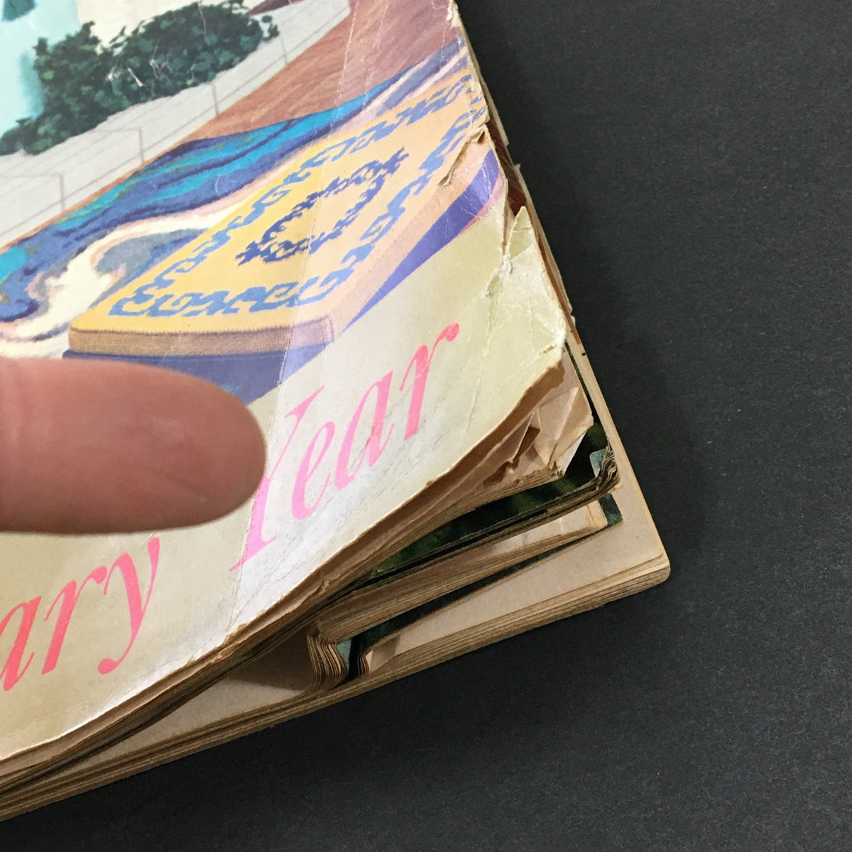 Side view of the VTG McCall's Needlework & Crafts Magazine Spring Summer 1969, showing the magazine's creased edges and a colorful design with a finger pointing.