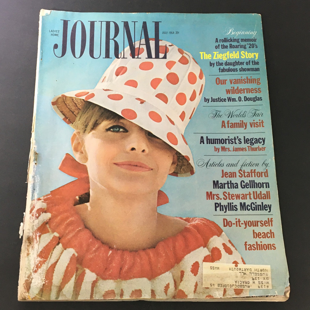 Cover of VTG Journal Magazine July 1964 featuring a model in a polka dot hat and red and white ruffled dress, highlighting articles by Jean Stafford and Martha Gellhorn.