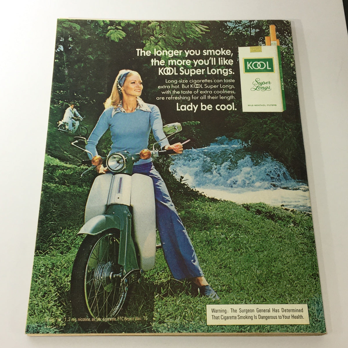VTG Journal Magazine April 1976 featuring a classic advertisement for KOOL Super Long cigarettes, showcasing a woman on a vintage scooter in a lush outdoor setting.