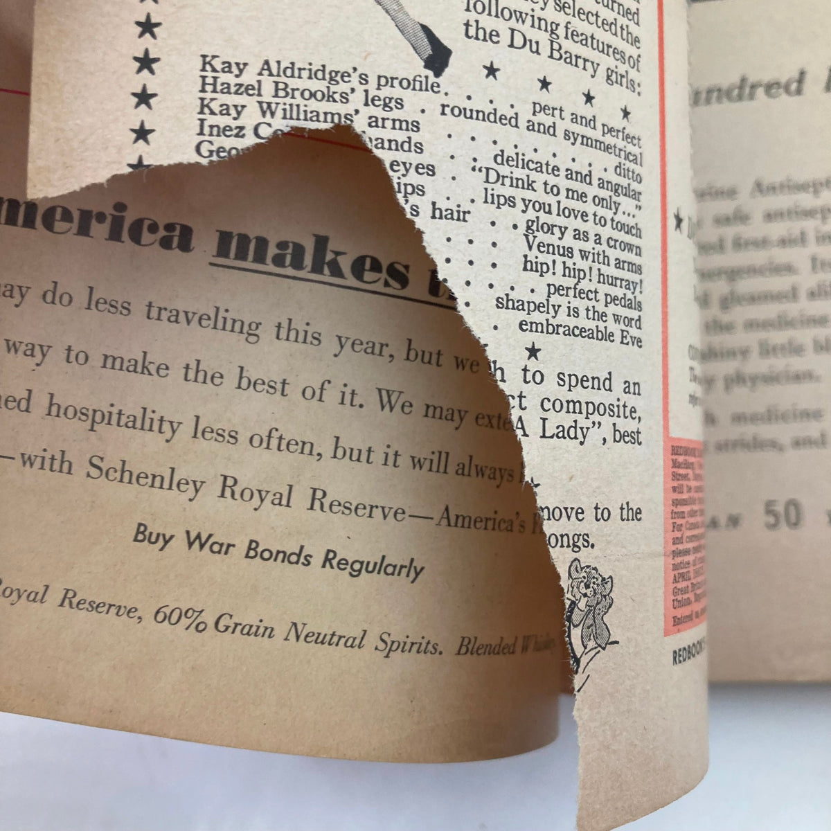 Interior page of VTG Redbook Magazine April 1943 with a prominent tear, showcasing vintage advertisements and cultural references from the early 1940s.