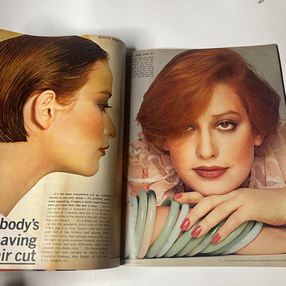 Magazine page featuring a beauty editorial on haircuts from Vogue Magazine July 1975, showcasing a model with a chic haircut and stylish makeup, photographed by Francesco Scavullo.