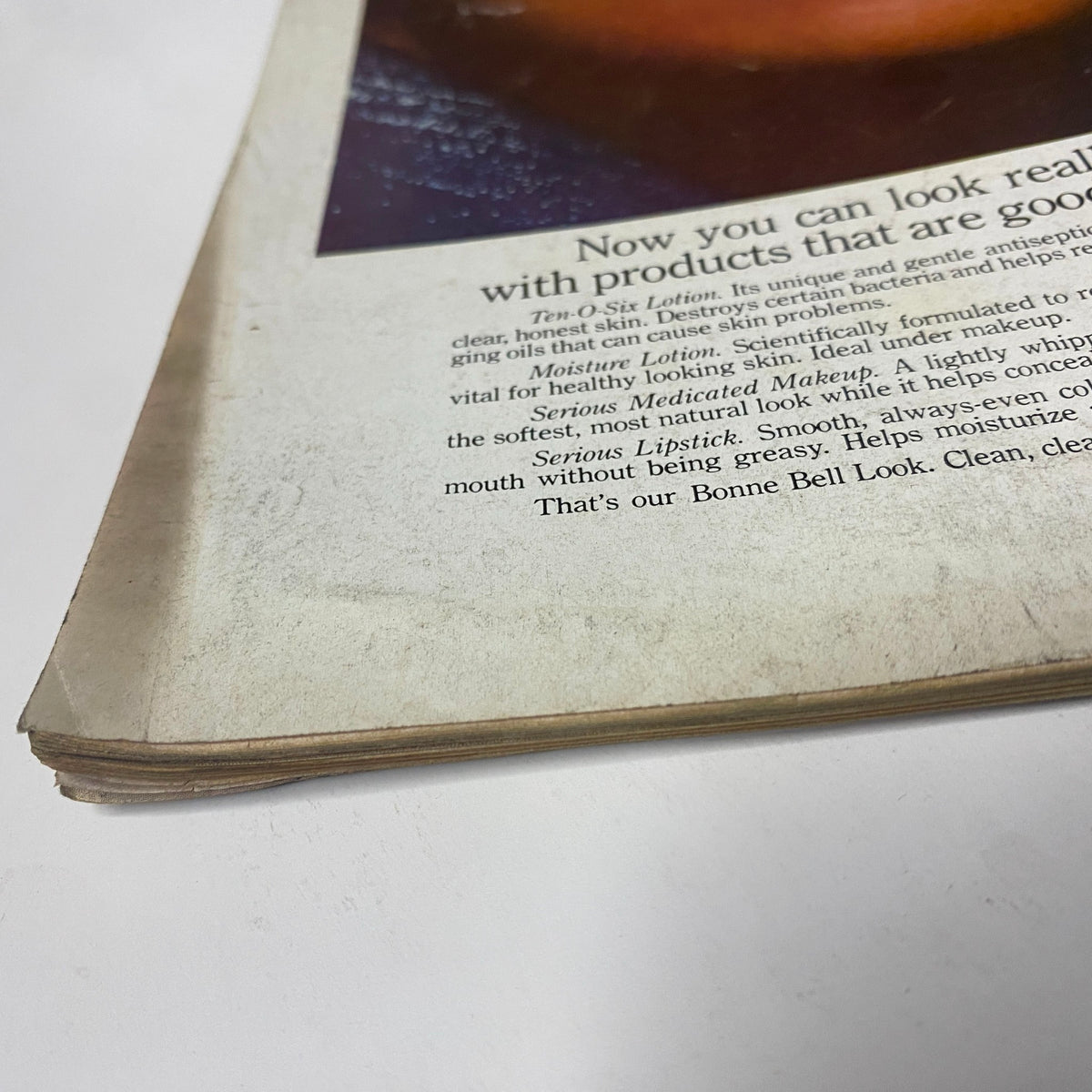 Close-up of the edge of a vintage magazine from Vogue Magazine July 1975, revealing signs of wear and aging including slight discoloration, highlighting the magazine's retro charm.