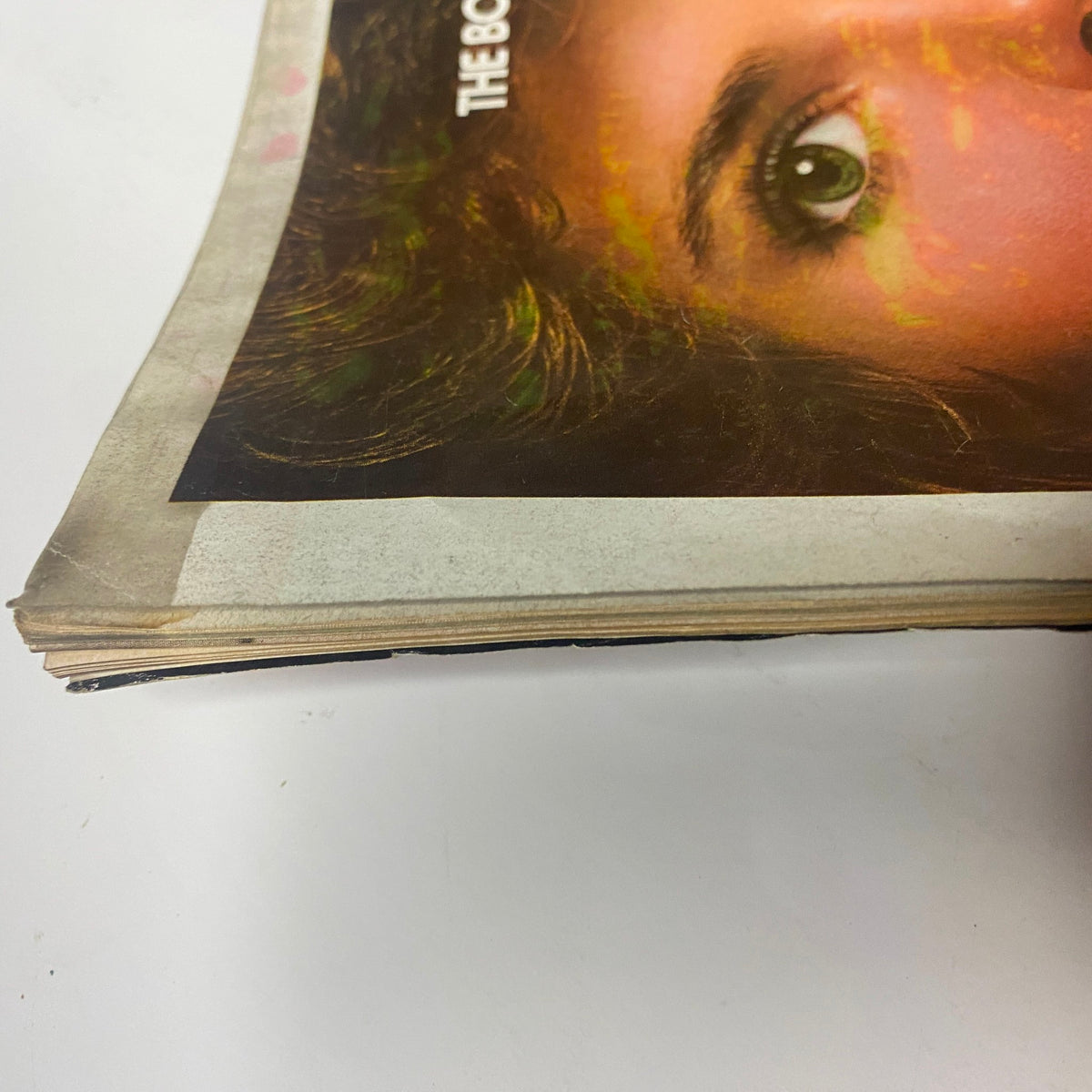 Image showing the worn edge of a Vogue Magazine July 1975 page, featuring characteristic vintage deterioration and highlighting the magazine's long history.