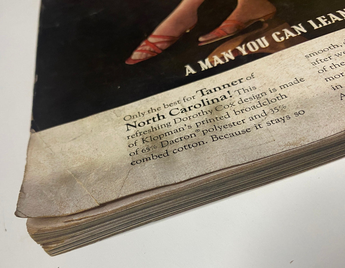 Close-up of the bottom corner of Vogue Magazine April 1, 1965 issue featuring Wilhelmina Cooper cover by Irving Penn, highlighting an advertisement for Tanner of North Carolina garments made of Klopman's printed broadcloth.