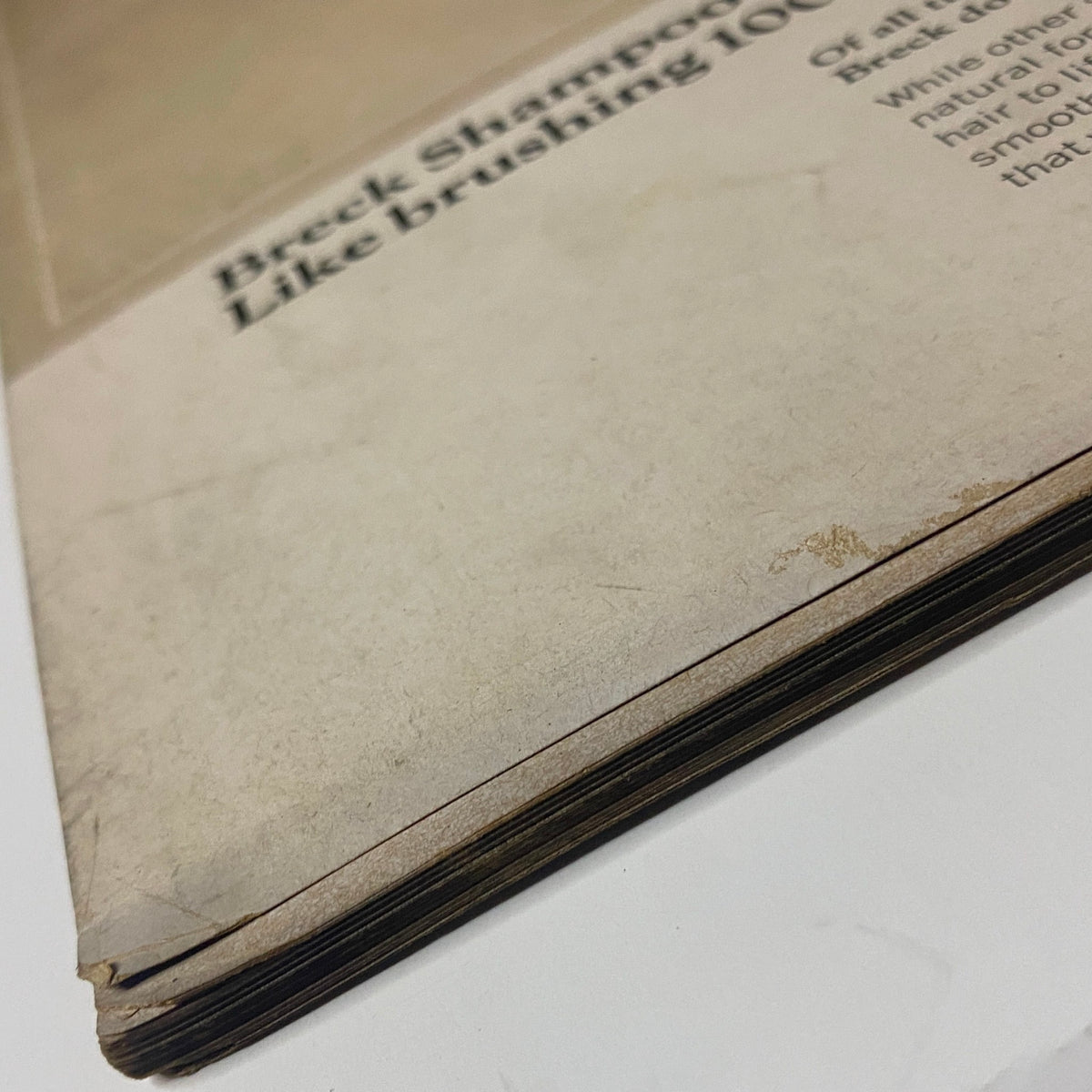 Close-up view of the spine and edge of a vintage Vogue Magazine from August 15, 1966 featuring Brigitte Bauer on the cover by Irving Penn, revealing signs of wear and age, indicative of its collectible status.