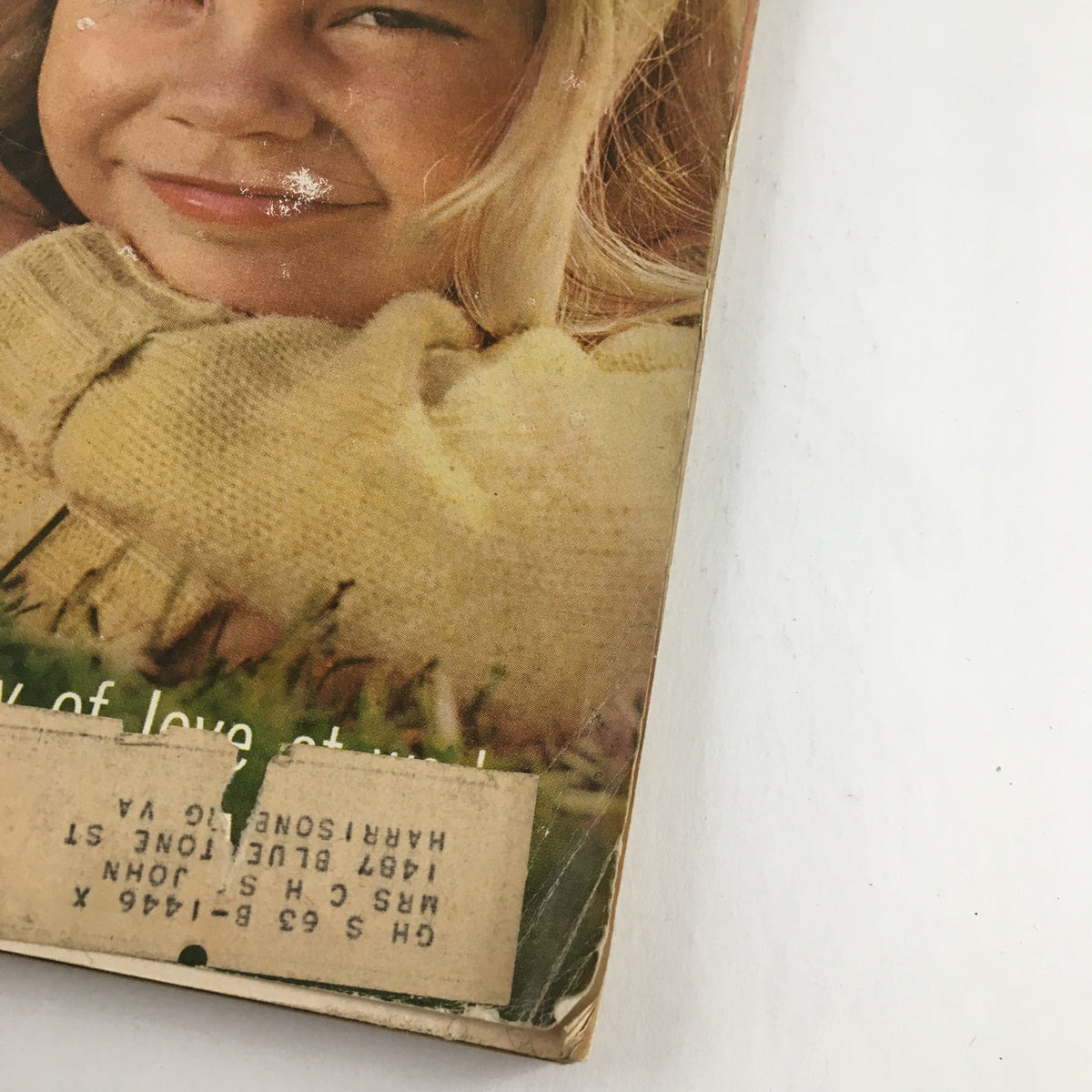Close-up of the cover of Good Housekeeping Magazine May 1963 showing a young girl smiling, with a small label affixed to the magazine.