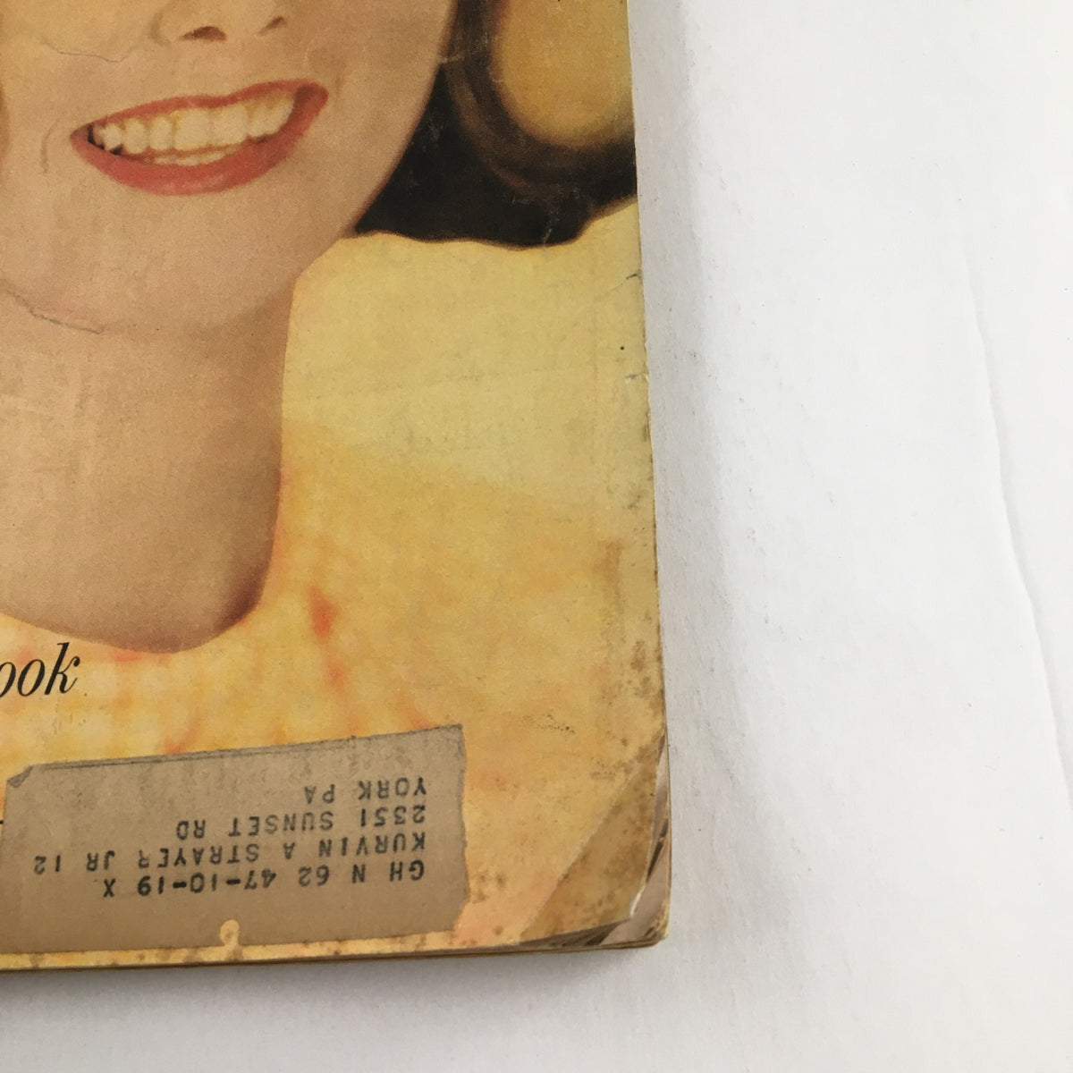 Close-up view of the cover of Good Housekeeping Magazine, April 1962, showcasing a smiling woman and the magazine's address label. The cover highlights 'All The Little Godfreys Childhood Memories' and includes promotional text about saving time.