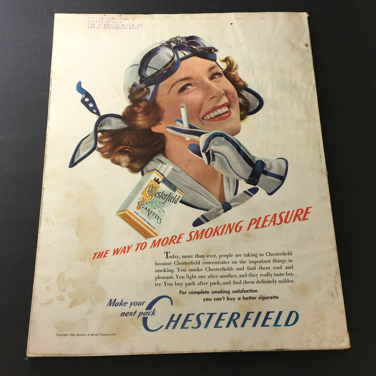 Vintage Chesterfield cigarette advertisement from Better Homes & Gardens October 1940. The ad features a smiling woman wearing racing goggles, promoting the brand's cool and pleasant smoking experience.