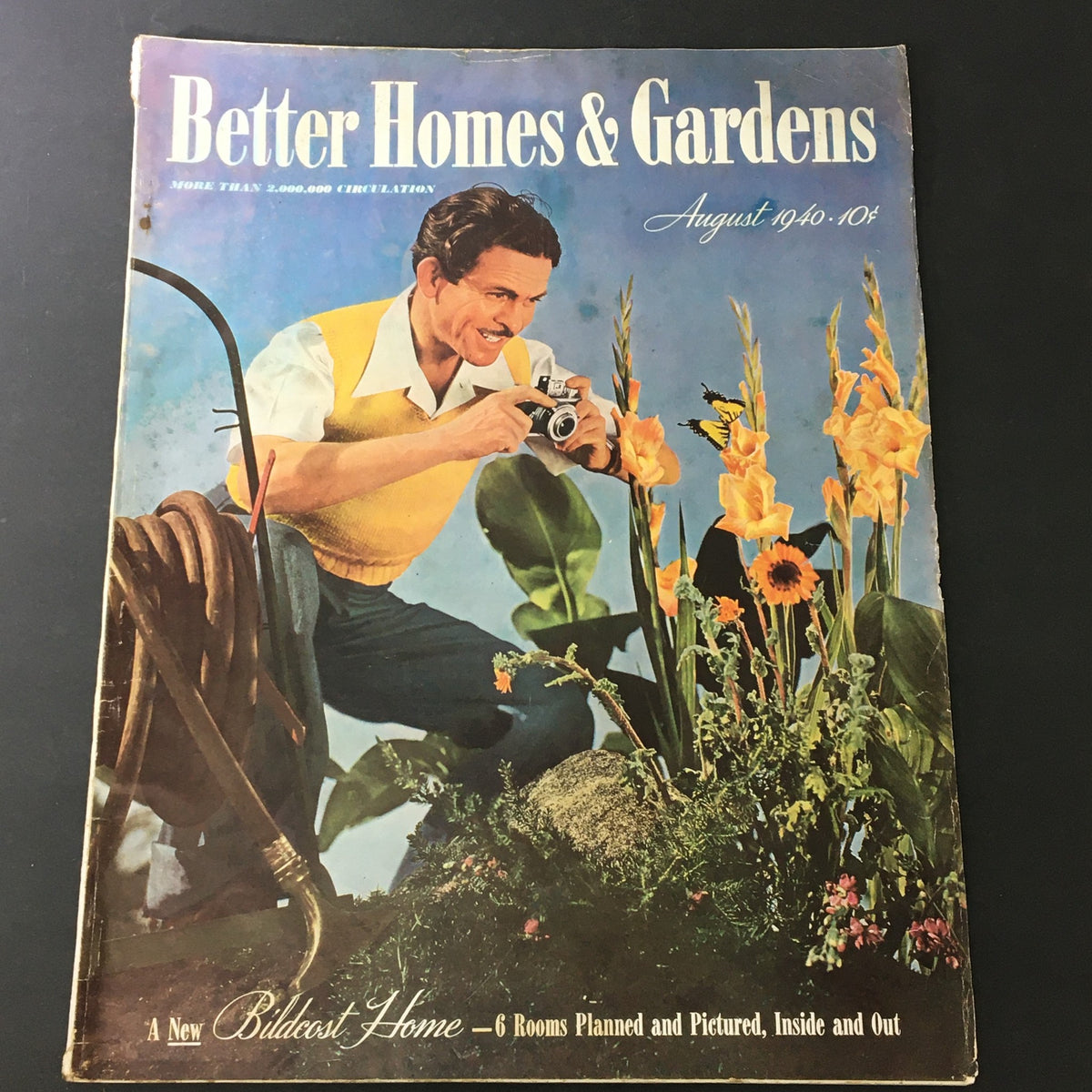 Cover of VTG Better Homes & Gardens August 1940 Edition featuring a man with a camera among flowers, showcasing vintage design elements.