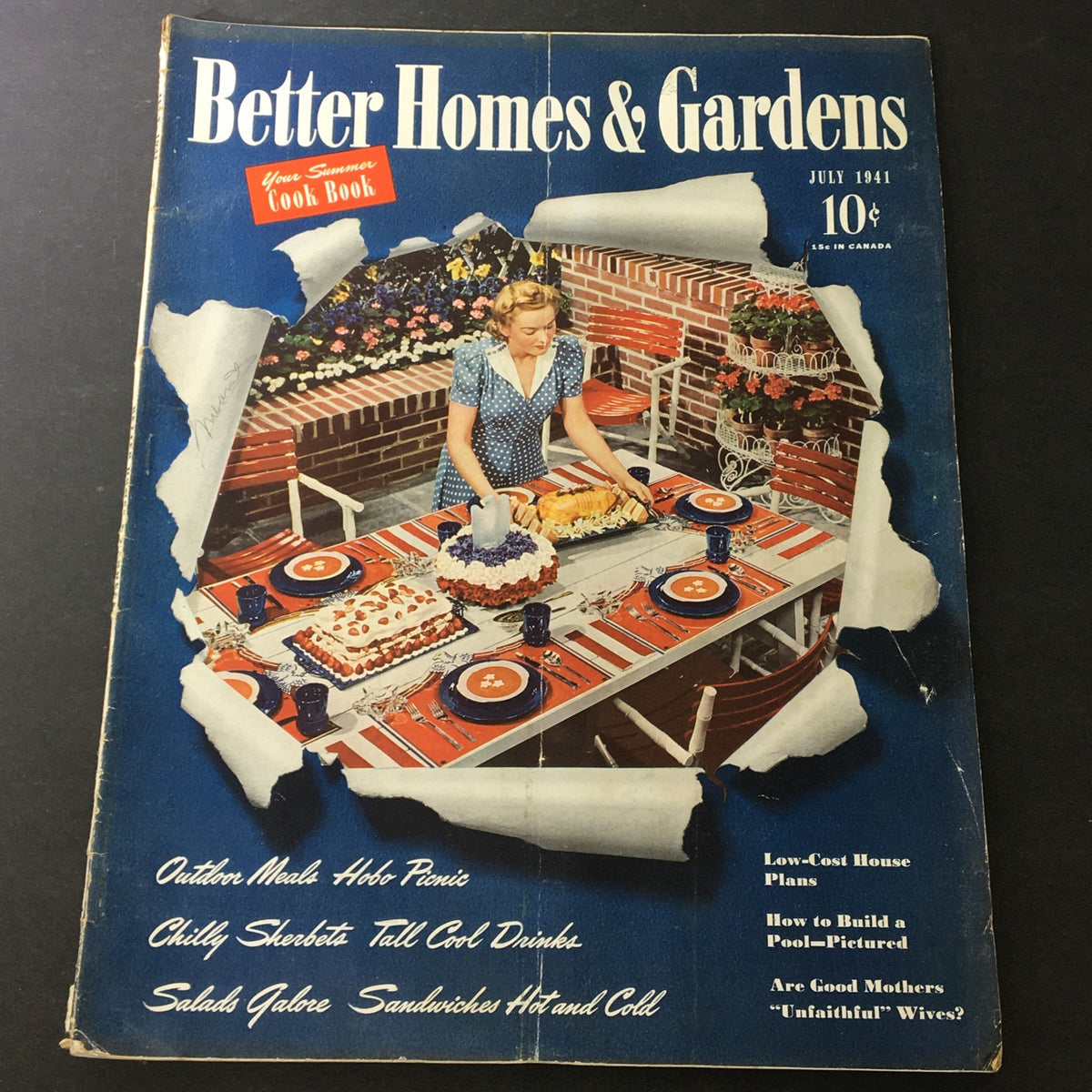 Cover of VTG Better Homes & Gardens July 1941 featuring a woman setting a festive outdoor table with a cake and drinks, surrounded by flowers and garden furniture.