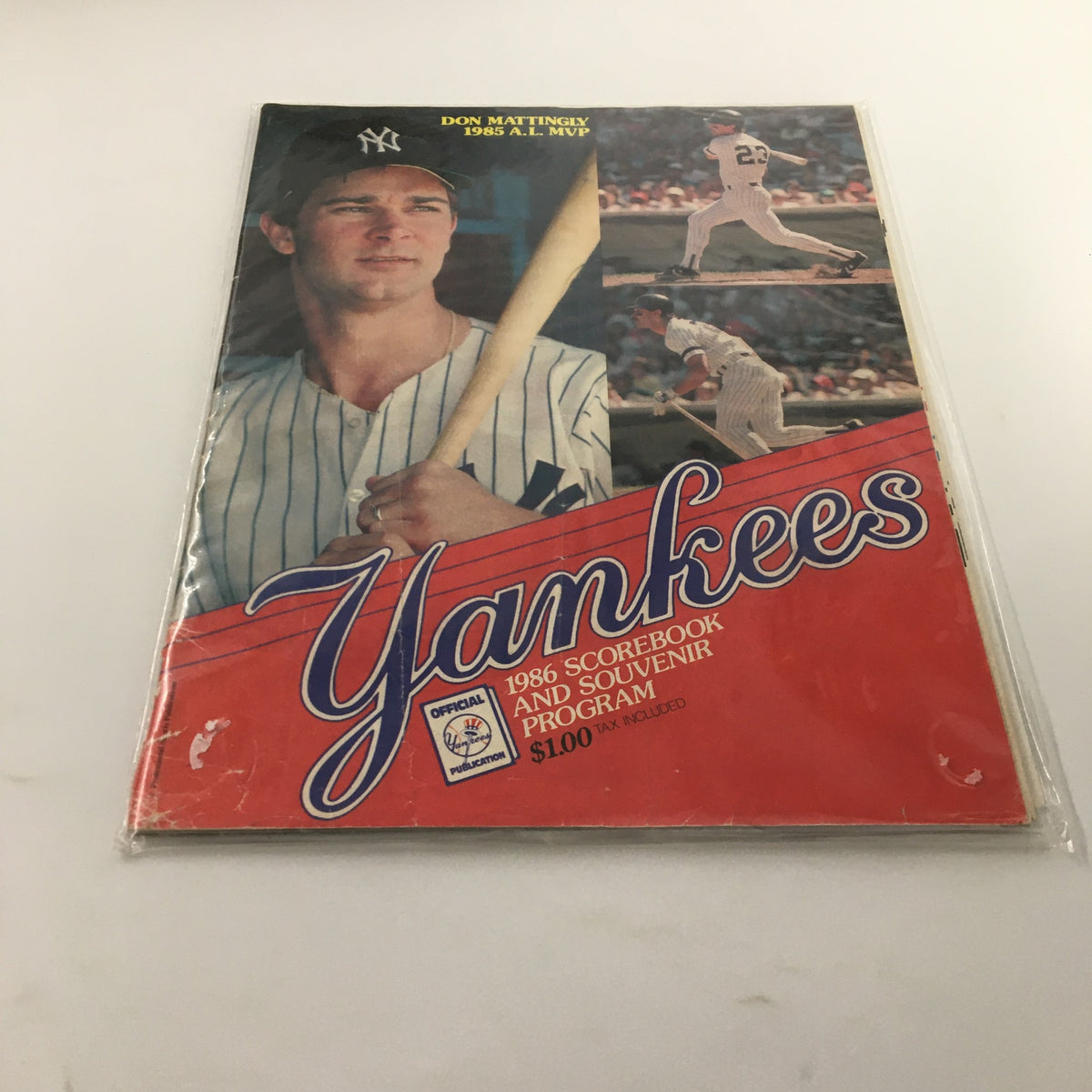 1986 Official Scorebook & Souvenir Program MLB New York Yankees Don Mattingly featuring Don Mattingly portrait in a Yankees uniform with bat, displayed in plastic protective covering.