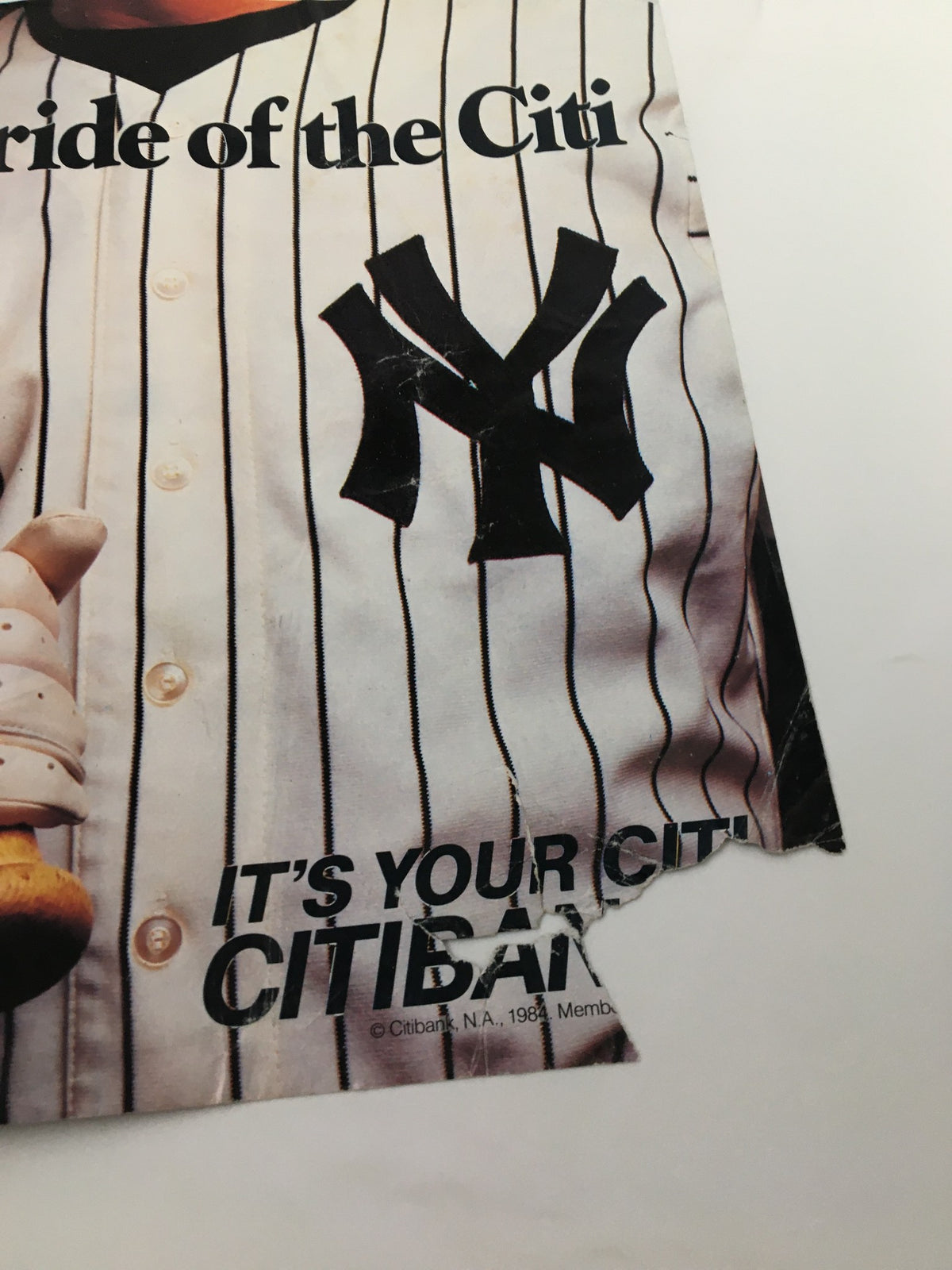 Close-up of the torn area on the cover of VTG Yankees Magazine May 9 1985, showing the iconic Yankees logo.
