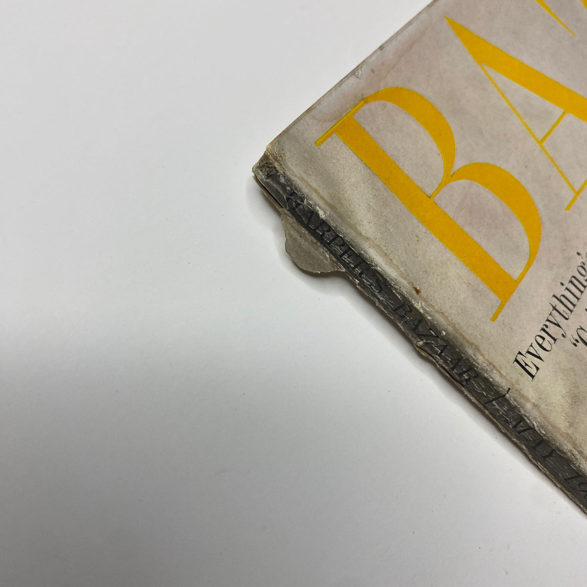 Close-up of the corner of the Harper's Bazaar Magazine May 1962, exhibiting minor wear and tear. This vintage cover features a model styled in bold fashion indicative of the 1960s.