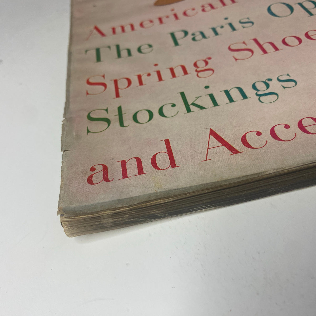 Close-up image of the edge of Harper's Bazaar Magazine March 1955, displaying some wear, indicating the vintage nature of this fashion collectible.