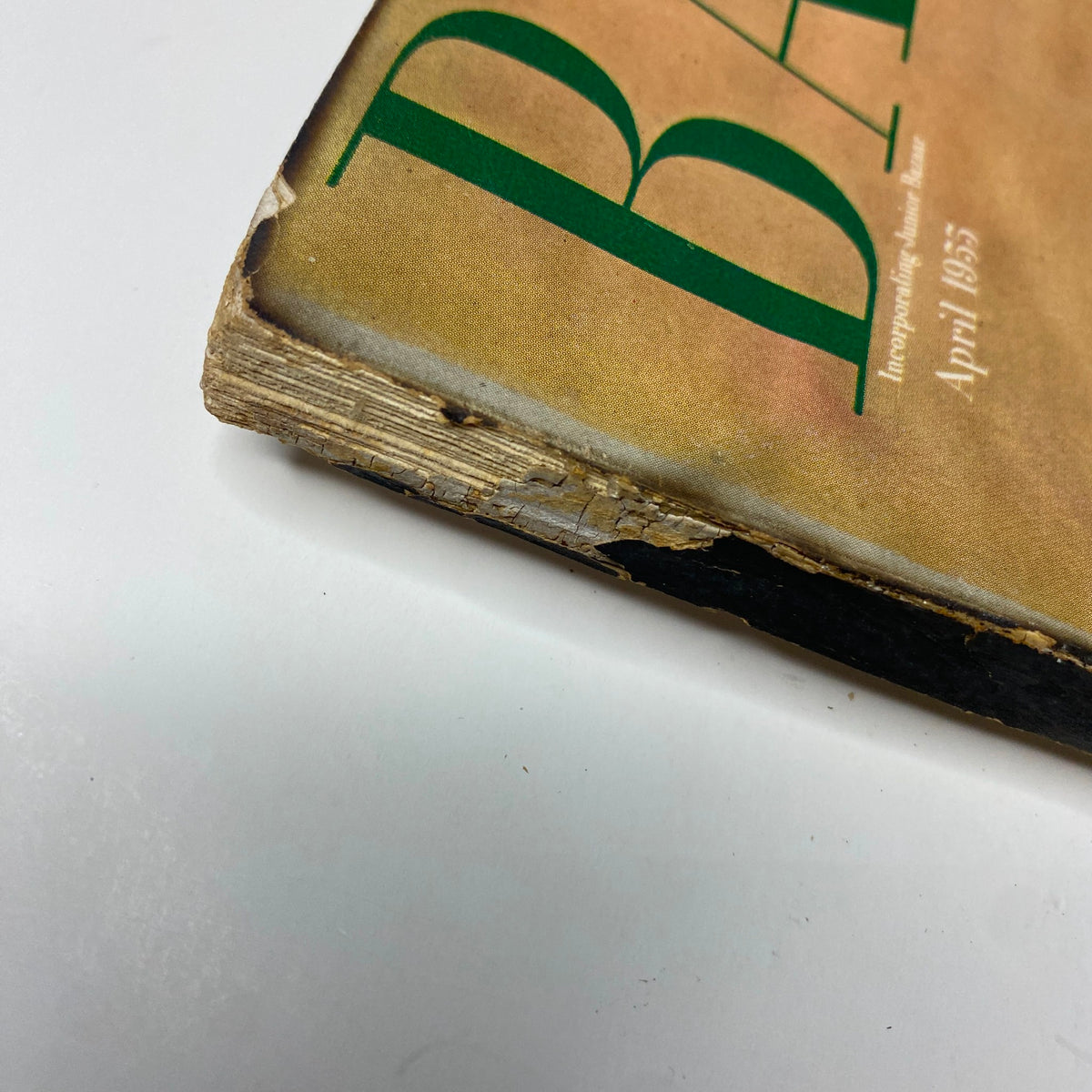 Detailed view of the edge of Harper's Bazaar Magazine April 1955, revealing age-related wear, part of the magazine's vintage charm.