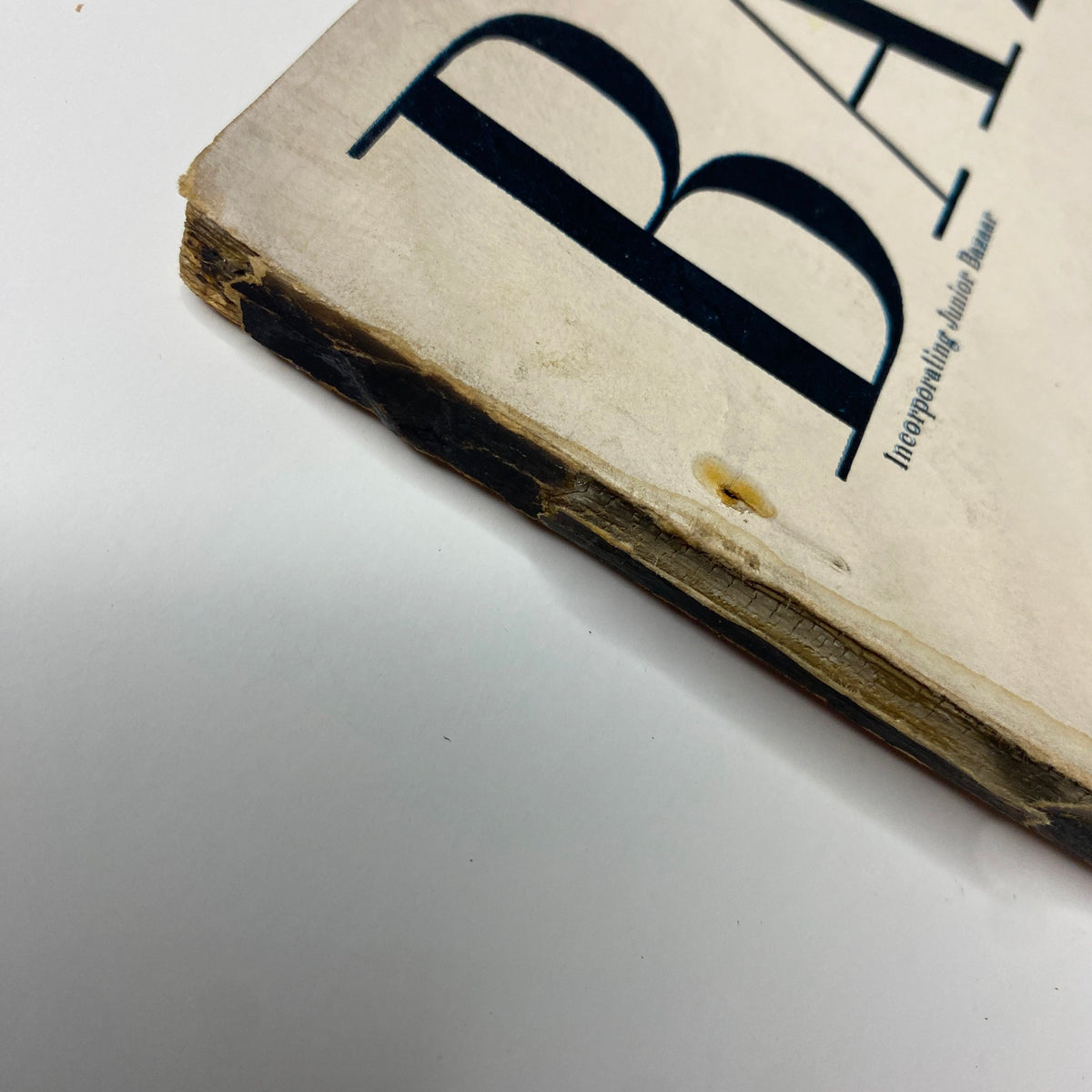 Close-up of the spine and cover edge of Harper's Bazaar Magazine May 1955 Suzy Parker Cover by Richard Avedon, showcasing wear and tear indicating its vintage condition.