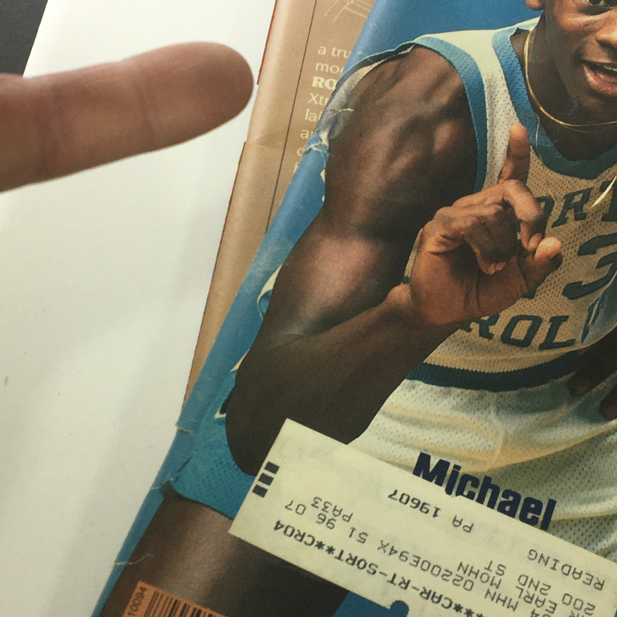 Close-up of Michael Jordan wearing a North Carolina basketball jersey from Sports Illustrated Magazine November 28, 1983, featuring his iconic pose and player number, showcasing the nostalgic element of vintage sports memorabilia.
