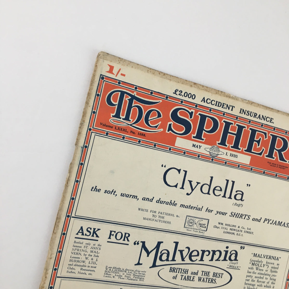 Close-up view of The Sphere Newspaper May 1, 1920, highlighting the title and detailed advertising for shirts and fabrics.