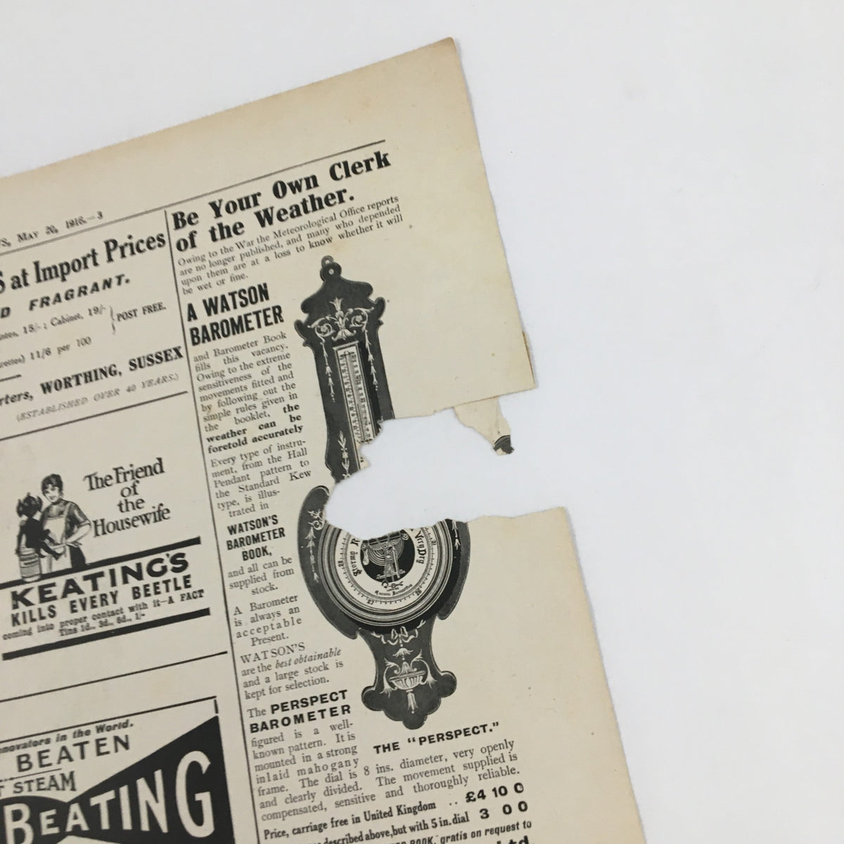 Close-up of an antique magazine page from The Illustrated London News May 20 1916 featuring a torn section and a weather barometer advertisement.