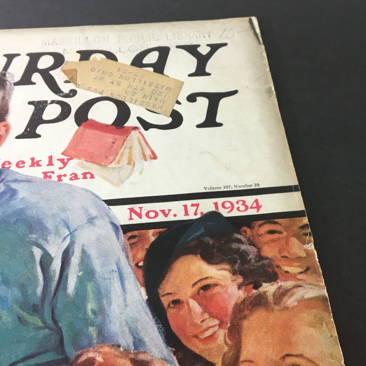 Close-up of the cover of VTG The Saturday Evening Post dated November 17, 1934, highlighting details like an address label and vintage typography with cheerful faces in the background.