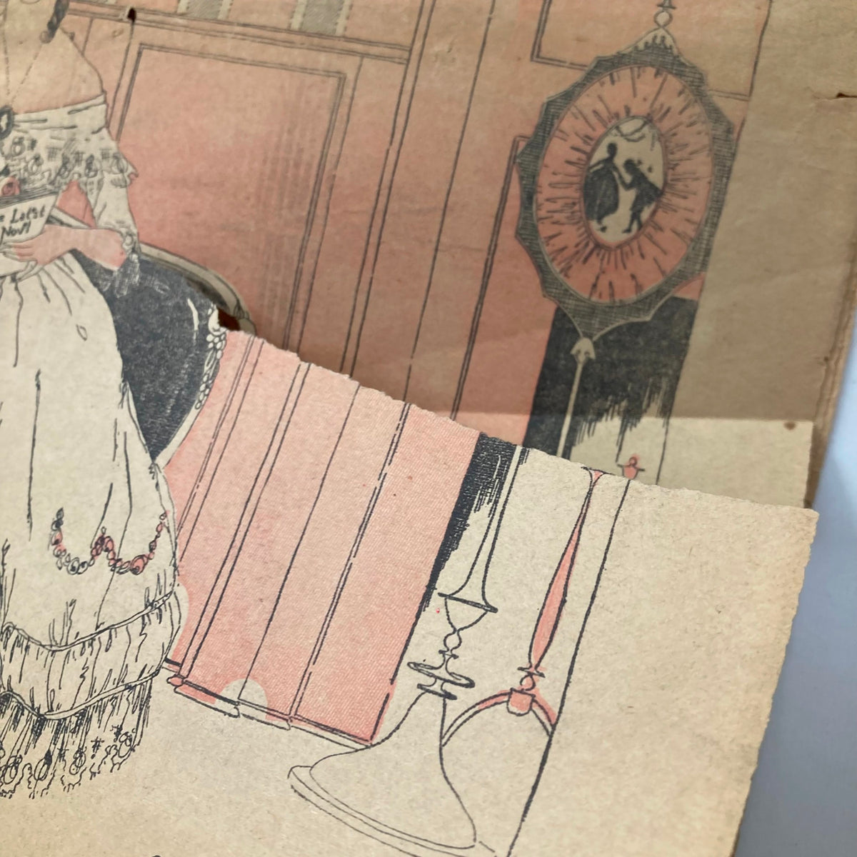 Detail shot of the vintage The Sunday Fiction Magazine December 10 1916, showcasing the intricate illustration of a dress and a decorative lamp.