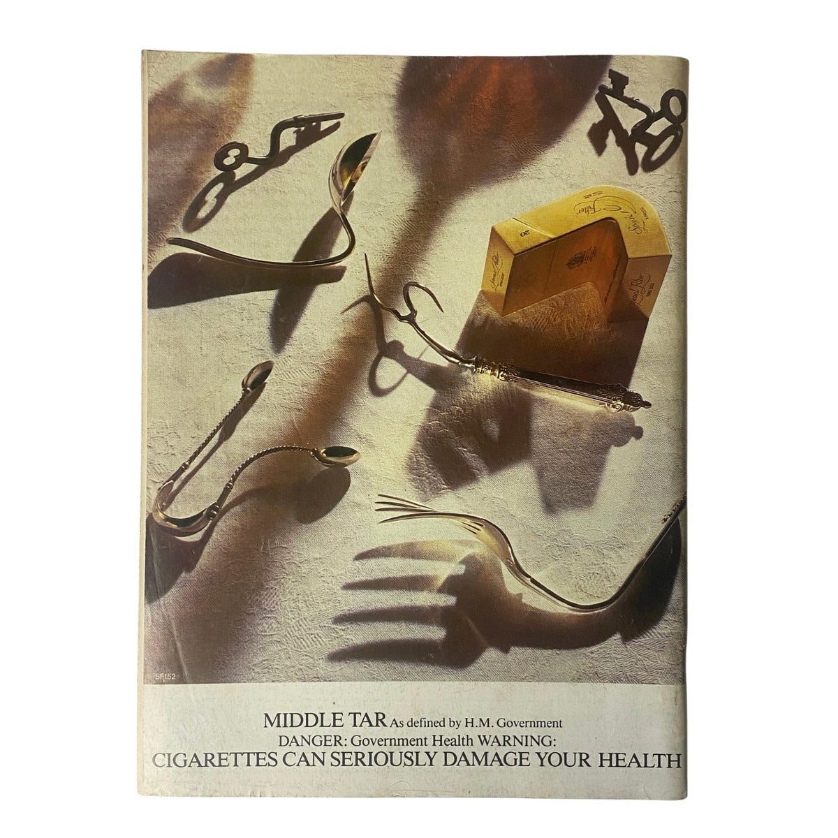 Back cover of Car Magazine UK July 1984 displaying an advertisement with a warning about the dangers of smoking, featuring artistic utensils and shadows.