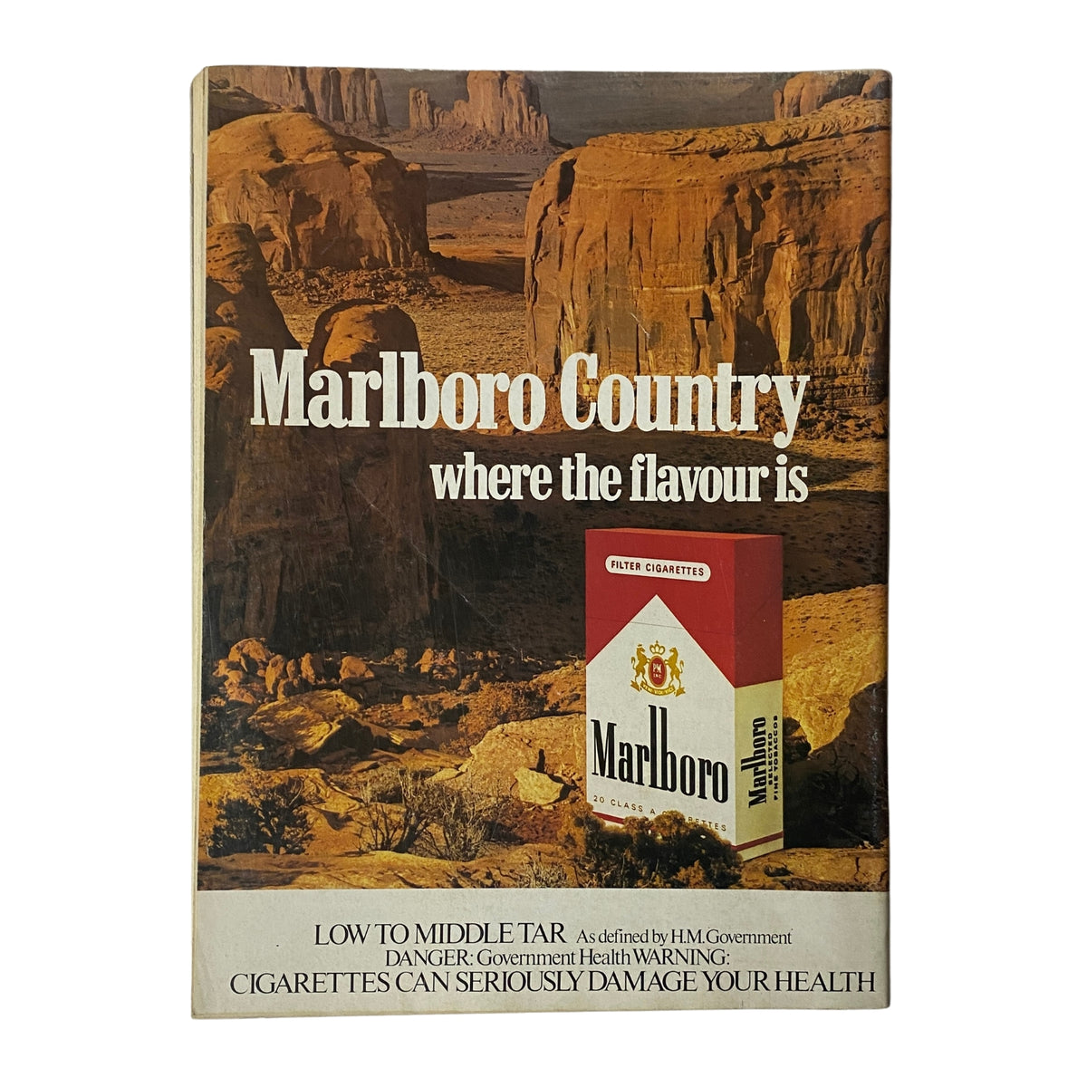 Cover page of Marlboro Country advertisement showcasing cigarette branding with scenic background and health warnings.