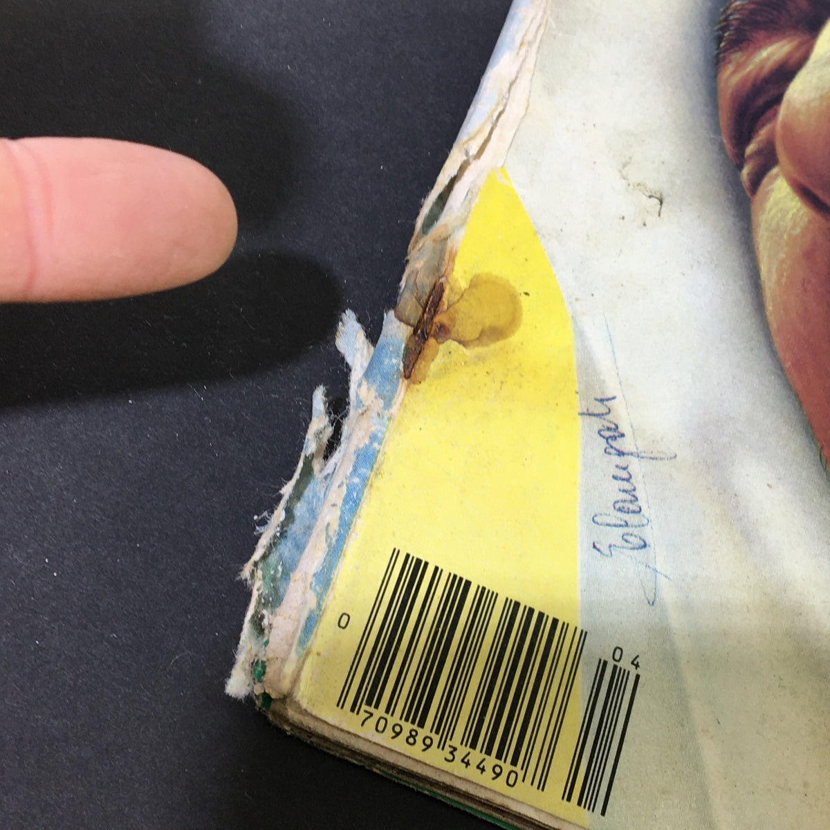 Close-up image of the National Lampoon Magazine April 1980 Vengeance Issue showing noticeable wear on the cover's edge and a handwritten note, emphasizing its vintage character.