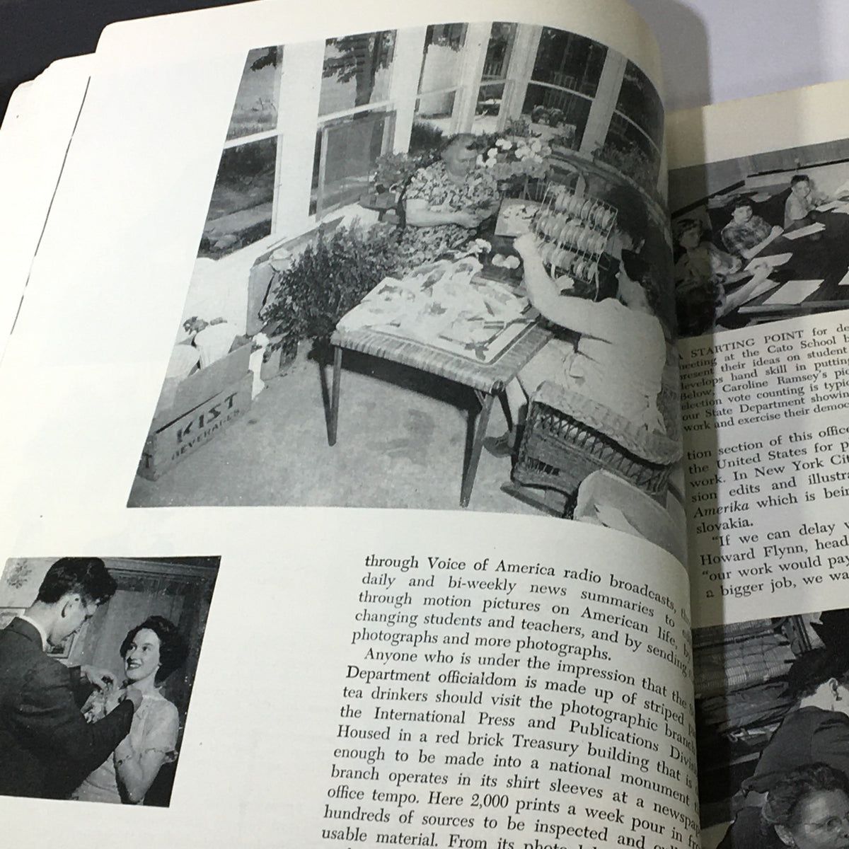 Photograph of a woman working on a floral arrangement with large windows in the background, featured in the VTG Modern Photography October 1949 magazine.