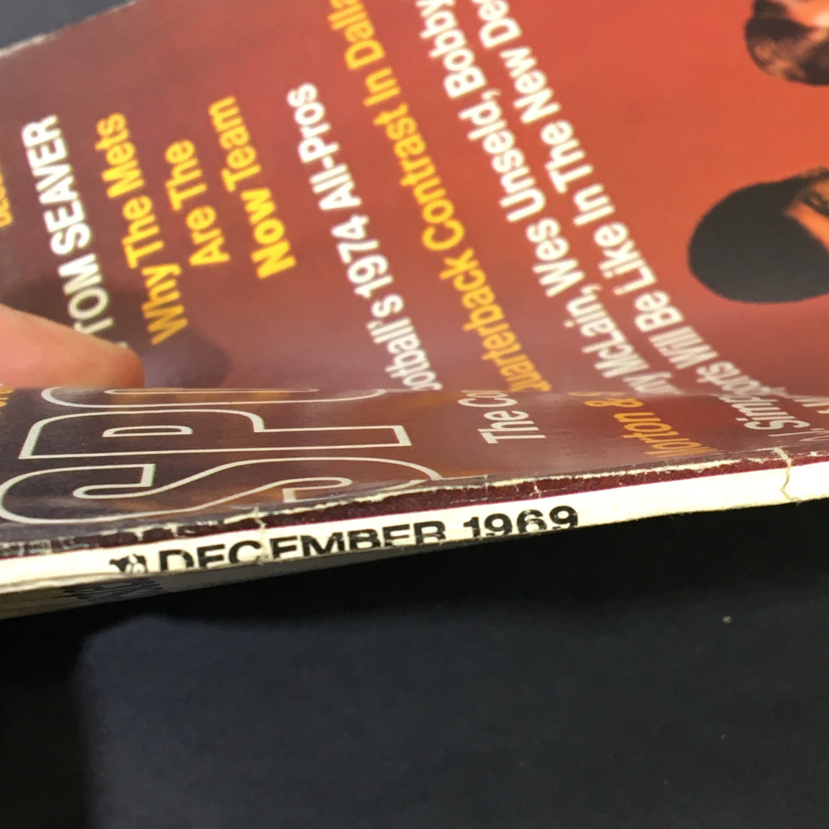 Close-up view of the VTG Sport Magazine from December 1969, featuring visible edge wear and the publication date. This collectible magazine showcases sports icons like O.J. Simpson, Craig Morton, and Roger Staubach.