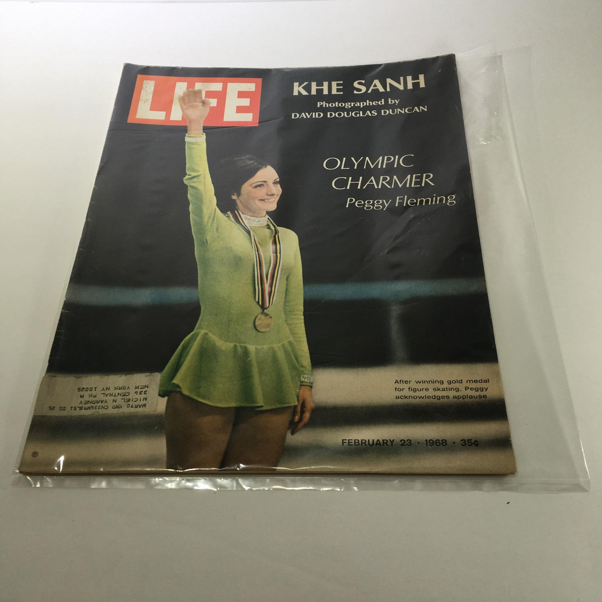 VTG Life Magazine from February 23, 1968 featuring Peggy Fleming, the Olympic Charmer, holding her gold medal for figure skating on the cover, showcasing a vibrant image of her in a green outfit.