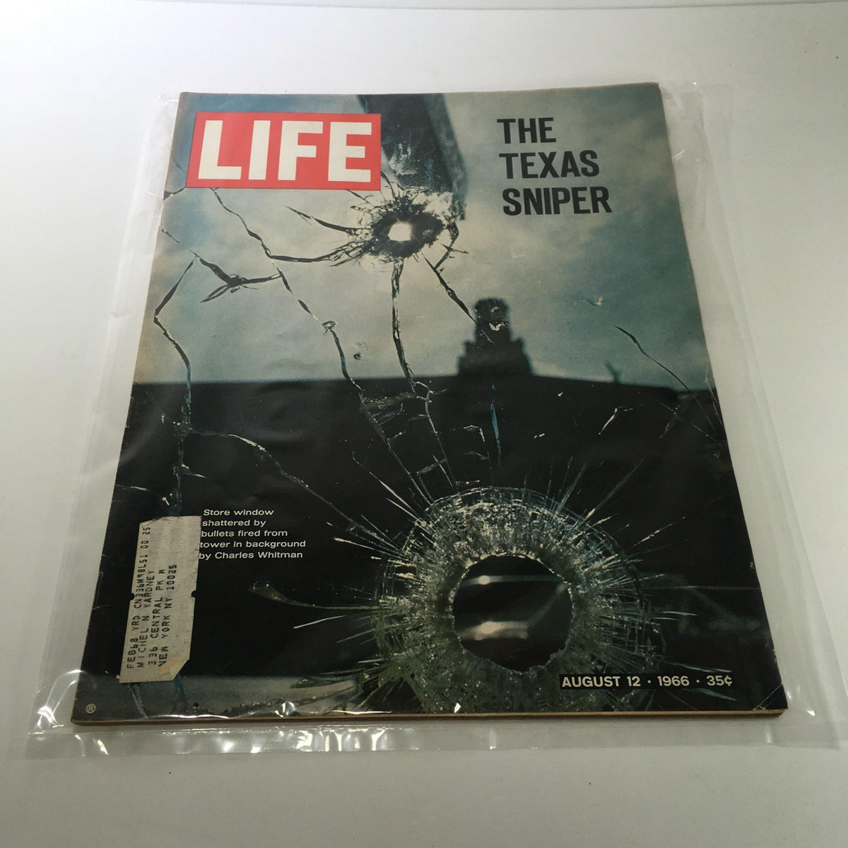Life Magazine cover from August 12, 1966 featuring an impactful image related to the Texas Sniper, Charles Whitman, showcasing a shattered glass window with bullet holes, representing a significant moment in American history.