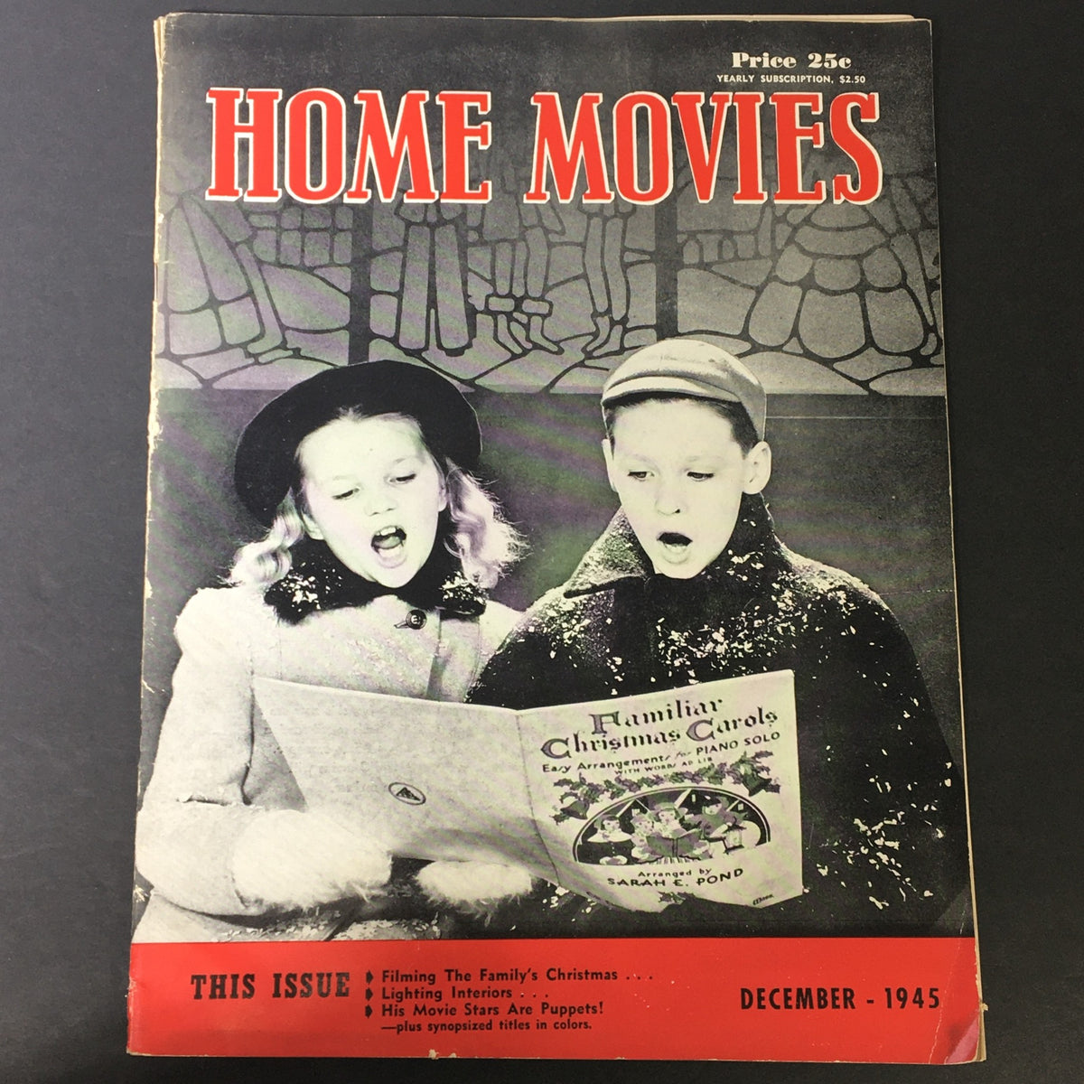 Front cover of VTG Home Movies Magazine December 1945 featuring children singing with a music sheet, encapsulating family holiday spirit.