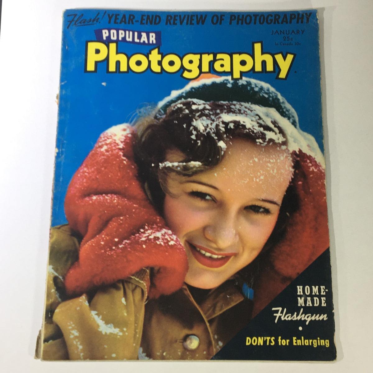 Cover of Popular Photography Magazine January 1942 Vol X #1 featuring a young woman in winter attire with snow on her hat, emphasizing home-made flashgun techniques.