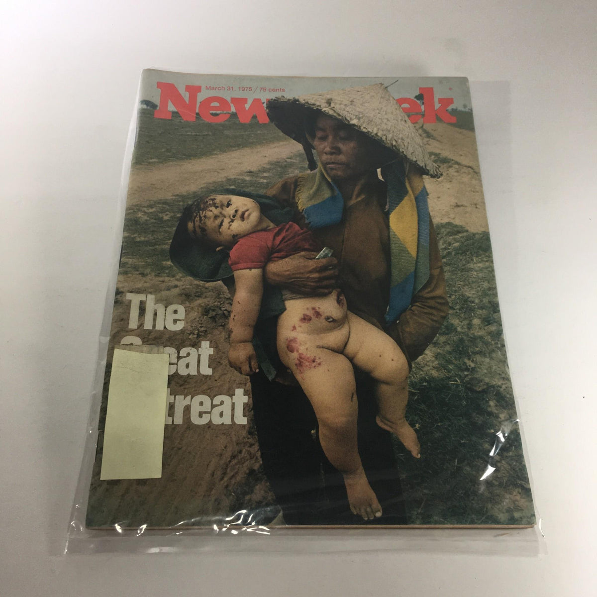 Vintage Newsweek magazine from March 31, 1975, featuring a poignant image on the cover titled 'The Great Retreat.' The cover shows a person holding a child in a rural setting, encapsulating historical events and societal issues of the mid-1970s.