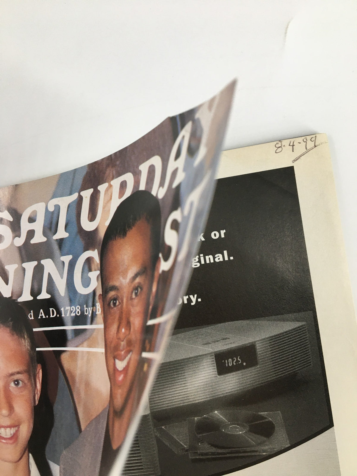 Close-up view of the cover of The Saturday Evening Post from September 1999, prominently displaying Tiger Woods and the magazine title. Details of the cover include references to media and health.