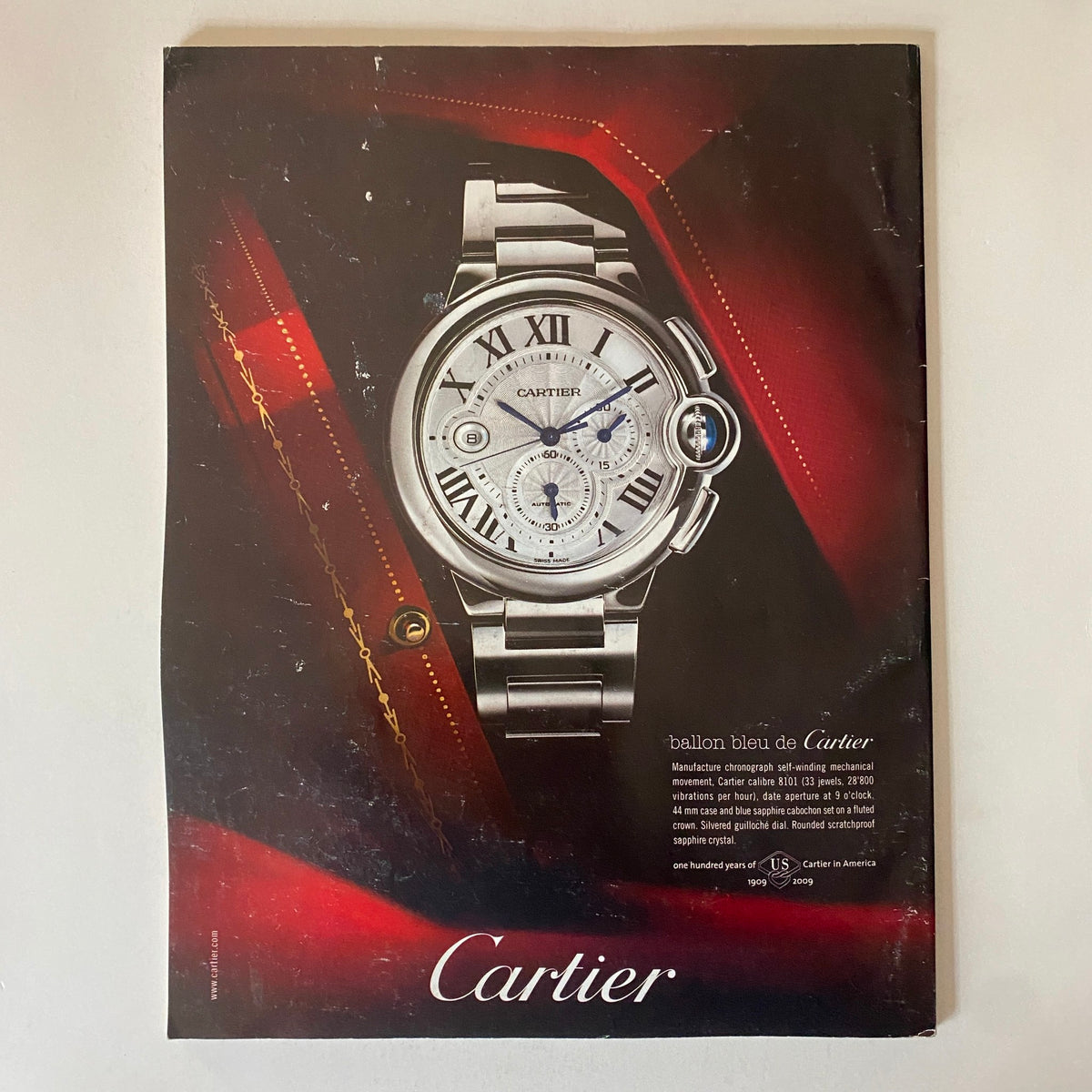 Vintage advertisement for Cartier featuring a silver wristwatch with Roman numerals, highlighted against a red background. This image is part of the Fortune Magazine December 7, 2009 issue discussing Procter & Gamble's CEO selection.