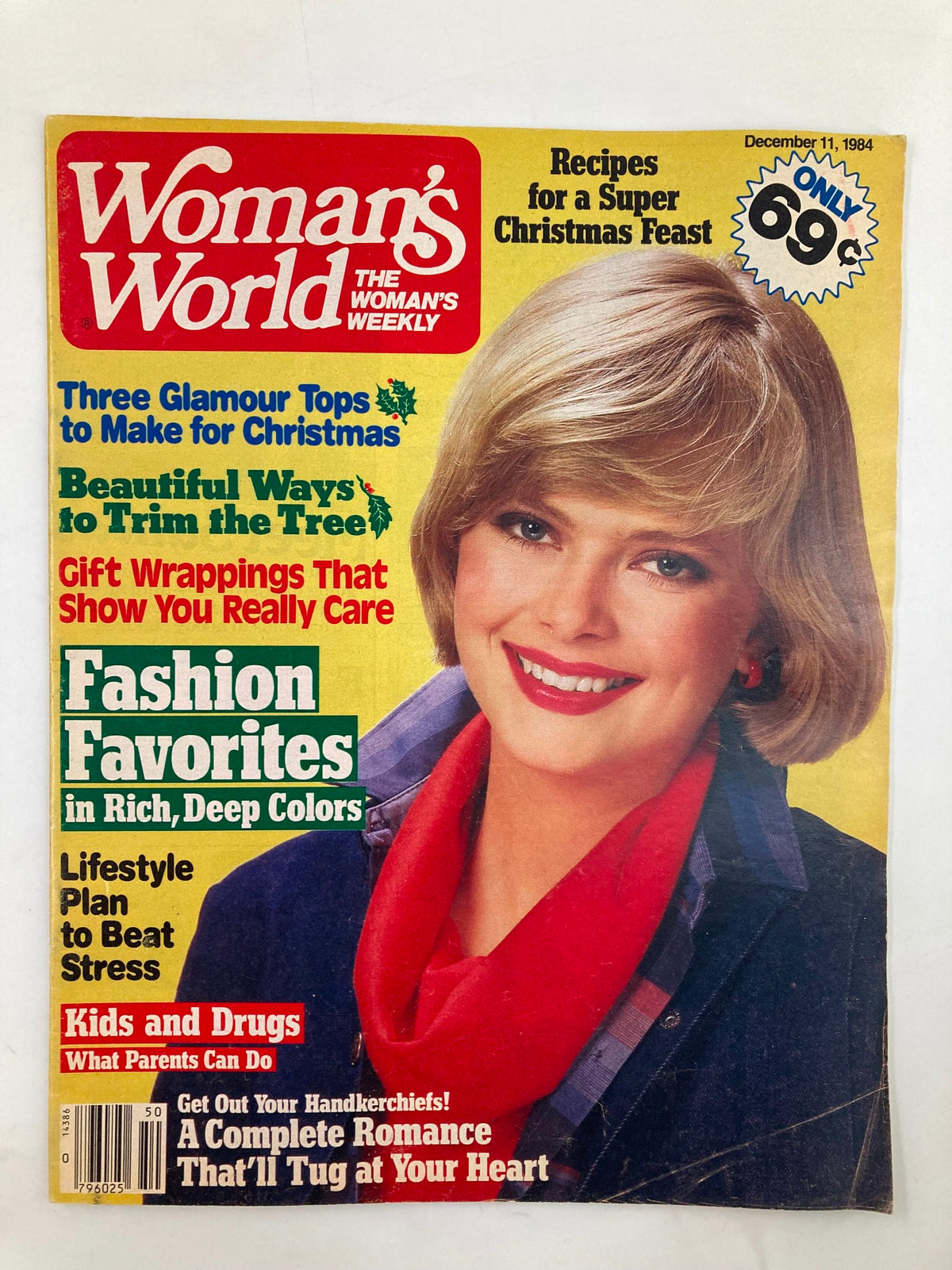 Cover of Woman's World Magazine from December 11, 1984 featuring 'Beautiful Ways to Trim the Tree.' The magazine showcases holiday-themed articles, with a smiling woman in a red scarf, highlighting festive fashion, lifestyle tips, and recipes for Christmas.