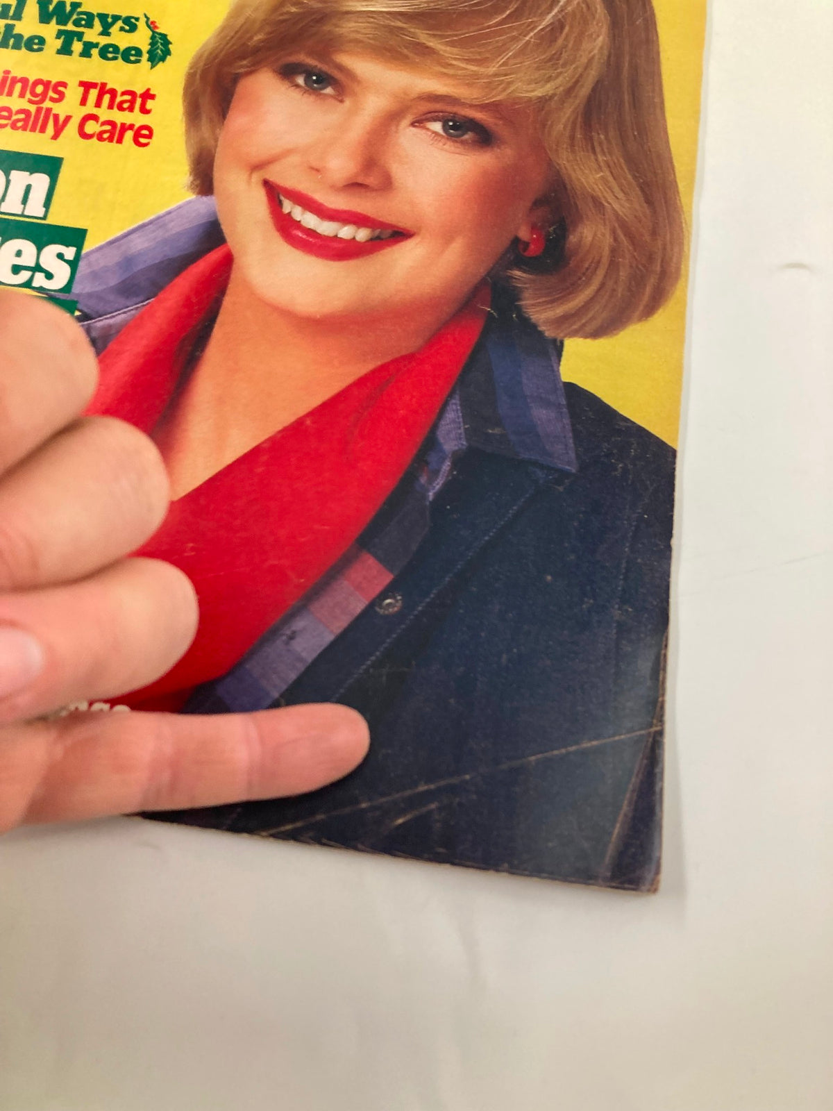 Cover of Woman's World Magazine December 11 1984 showcasing a smiling woman with blonde hair wearing a red scarf and blue jacket, promoting beautiful ways to trim the tree.